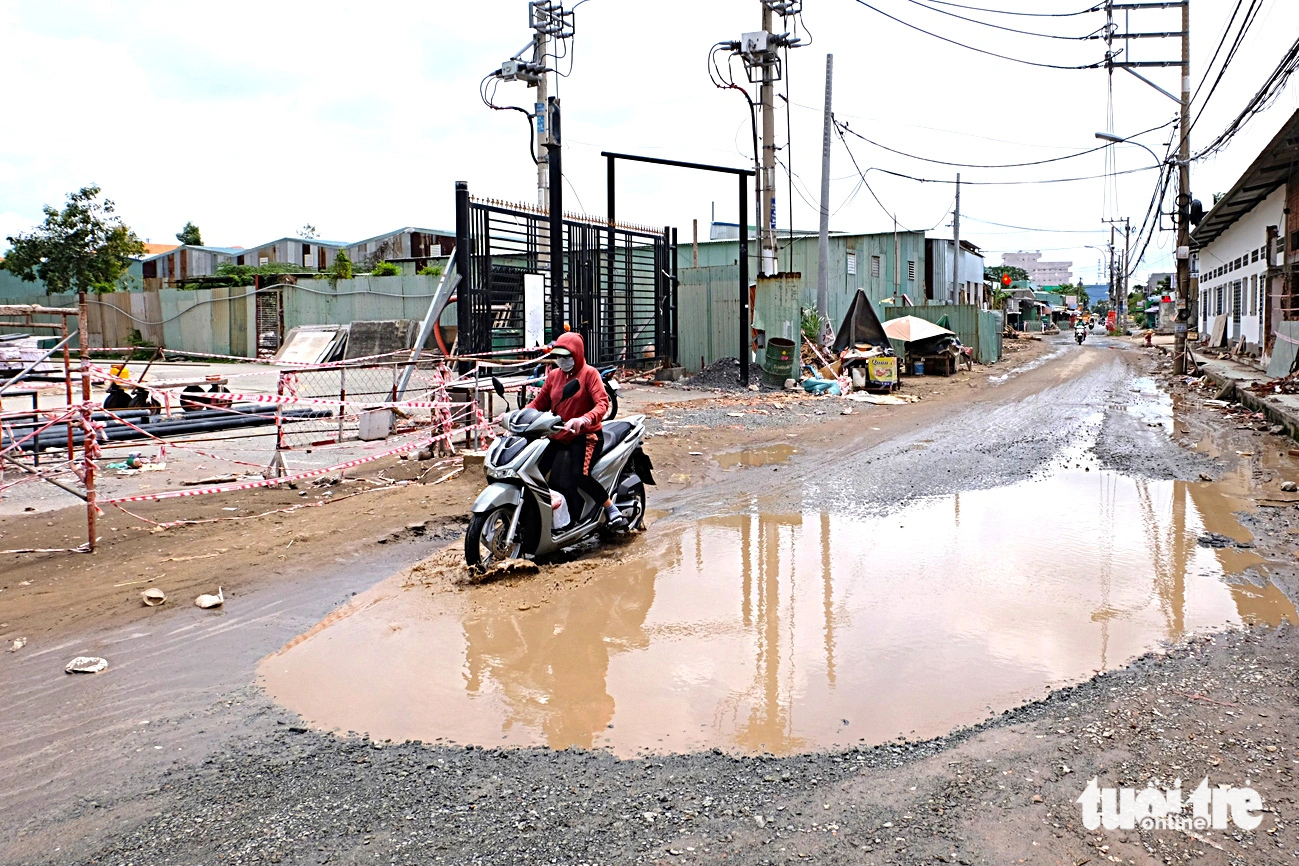A large waterlogged pothole is seen on Ho Van Long Street in Binh Tan District. Photo: Phuong Nhi / Tuoi Tre
