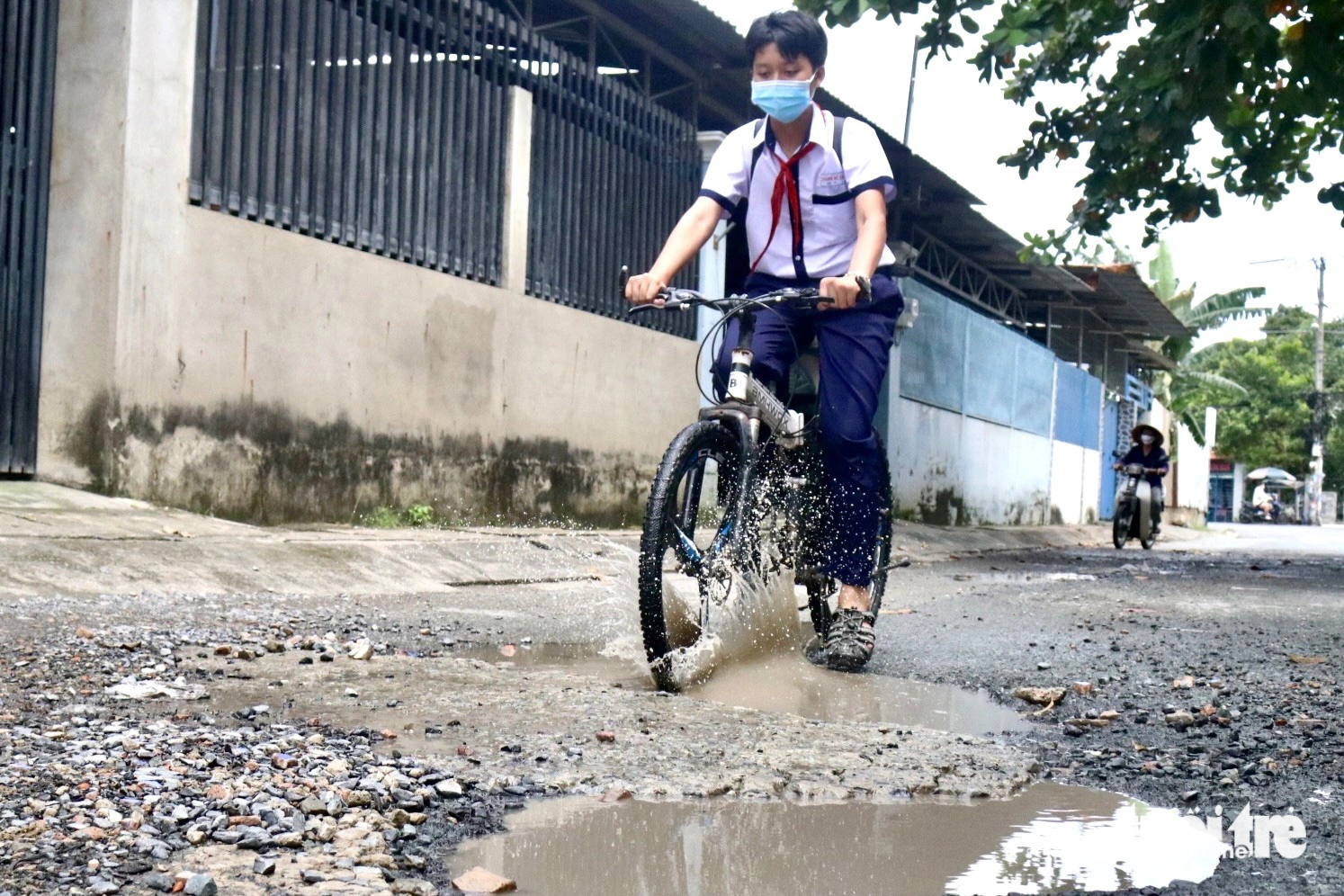 A student hits a pothole while cycling on Giac Dao Street. Photo: Tien Quoc / Tuoi Tre