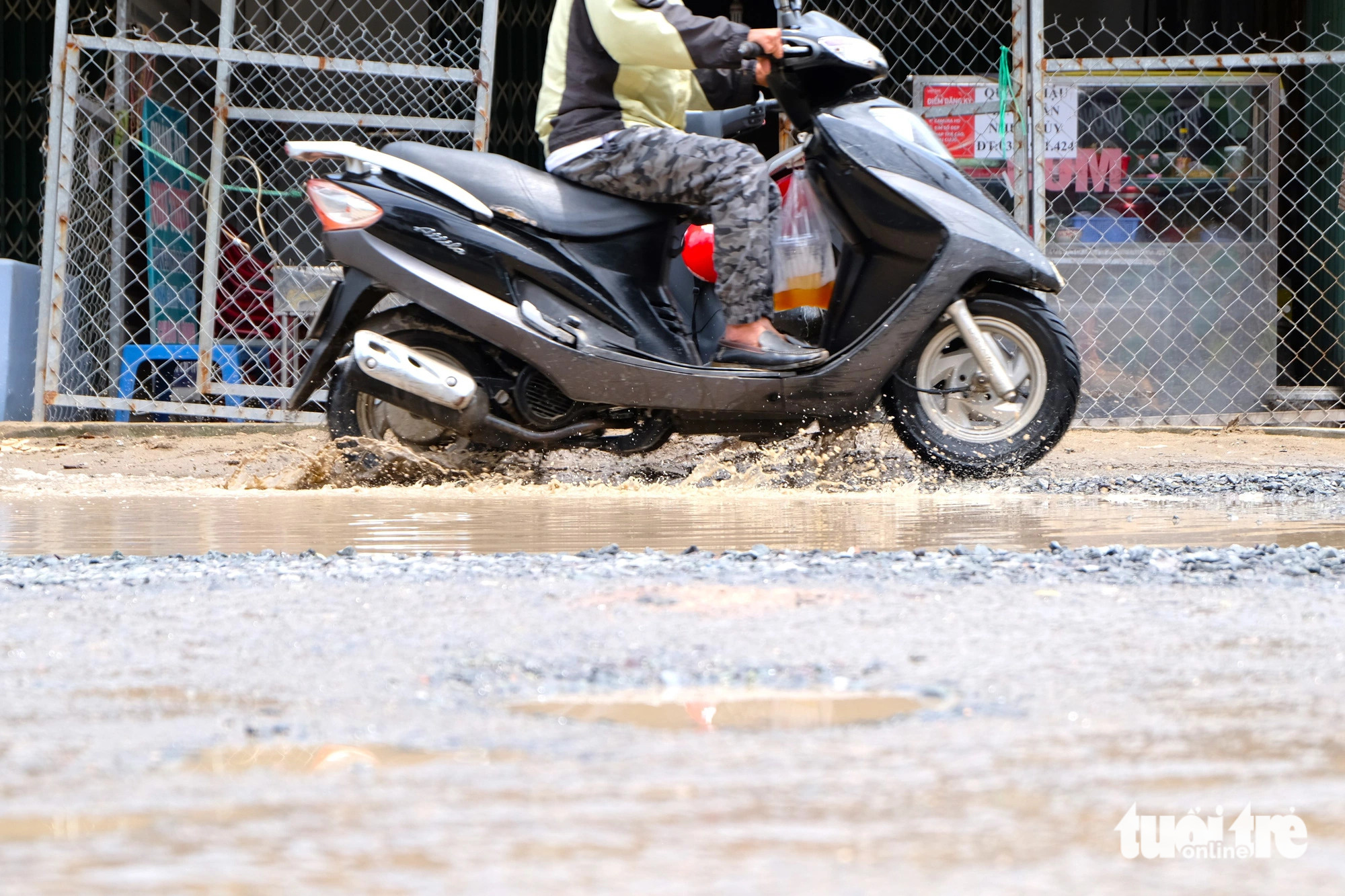 Many women and old people fell off their motorcycles and bicycles due to potholes on Ho Van Long Street, especially when the route is submerged in rainwaters. Photo: Phuong Nhi / Tuoi Tre