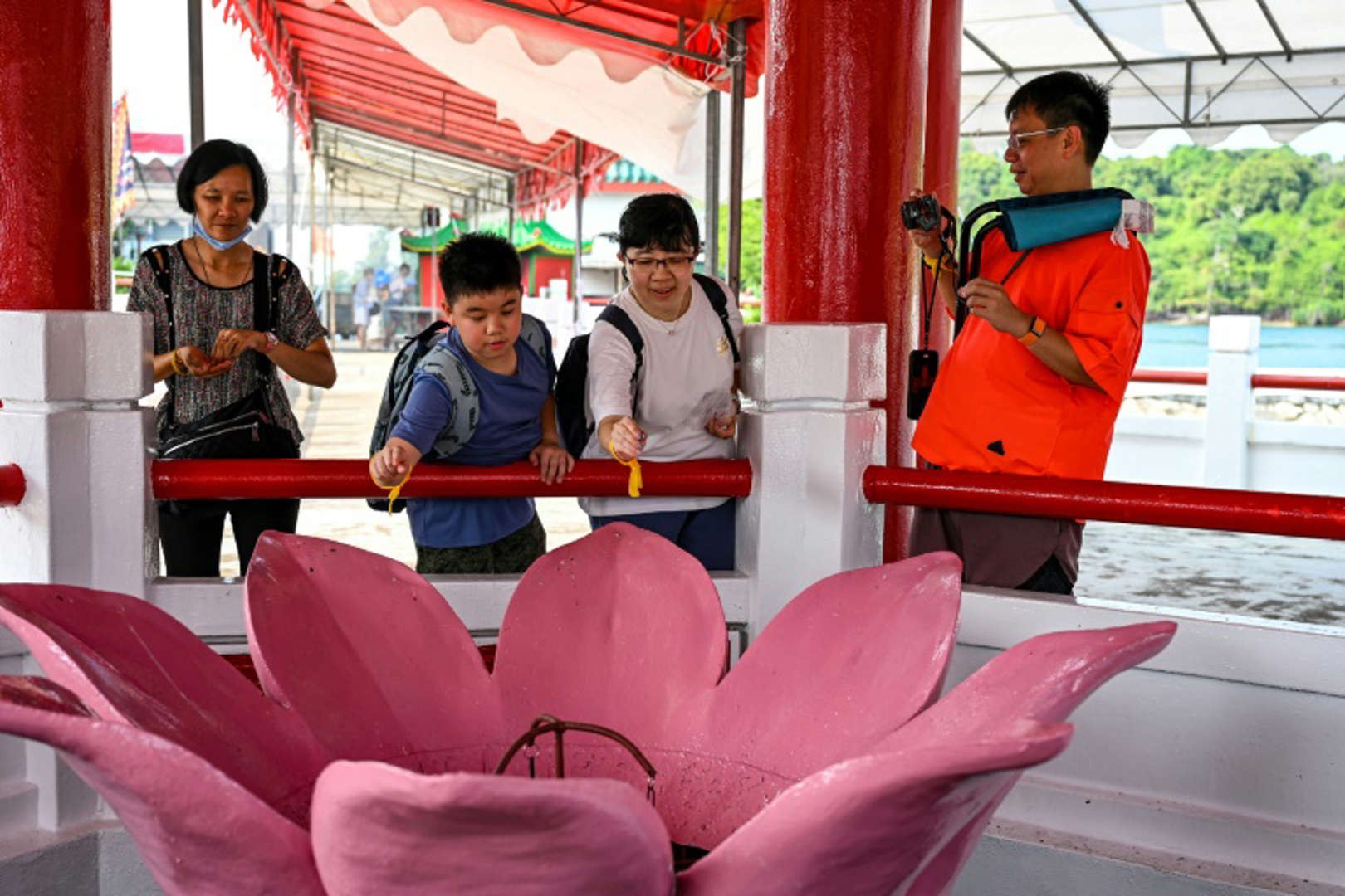Visitors throw coins into a wishing well at the temple.