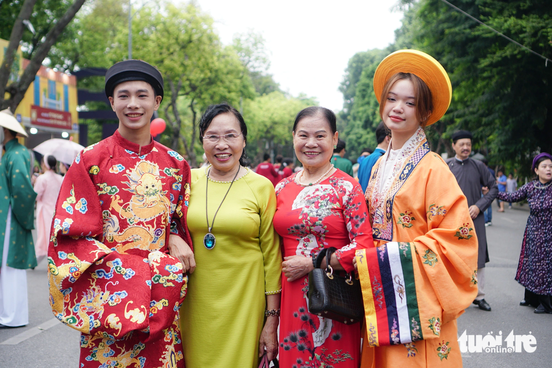 Pham Thi Hien (in yellow ‘ao dai’), a Hanoi resident, hails young people for organizing the event. Photo: Nguyen Hien / Tuoi Tre