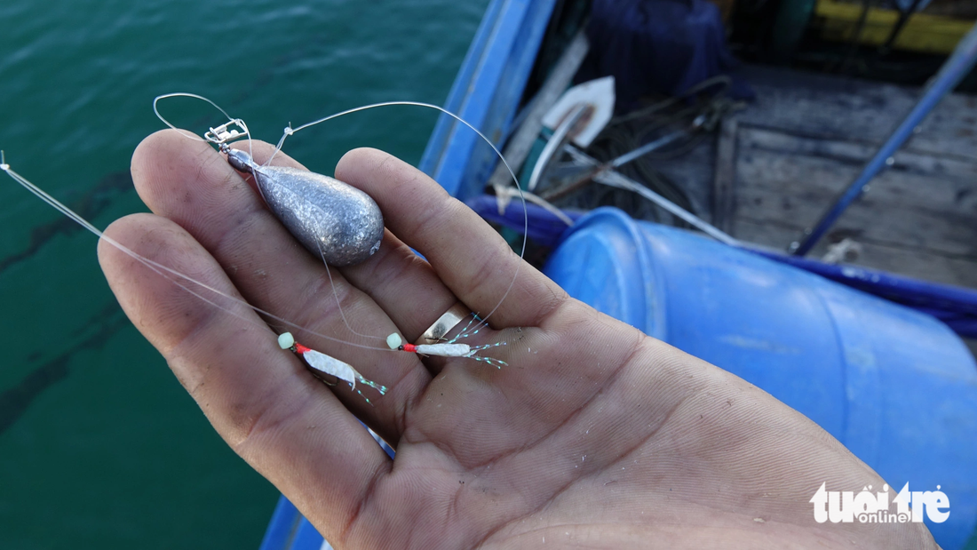 A fishing rod features fluorescent feathers that mimic bait, luring fish to bite the hook when submerged. Photo: Chi Cong / Tuoi Tre