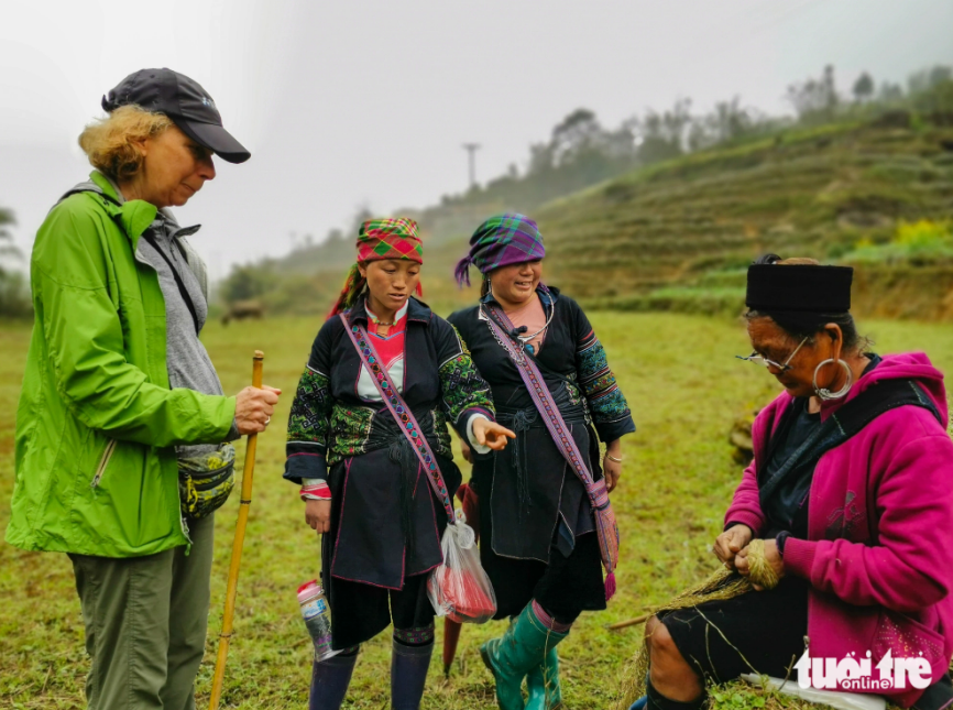 Ly Thi Co introduces the traditional knitting craft to foreign visitors. Photo: Vu Tuan / Tuoi Tre