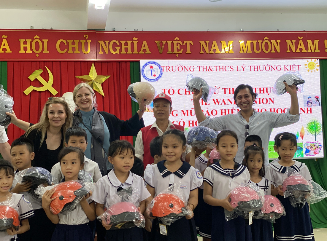 Ambassador of Sweden in Vietnam Ann Måwe and her Swedish friends give helmets to students in Hoi An City. Photo: B.D. / Tuoi Tre
