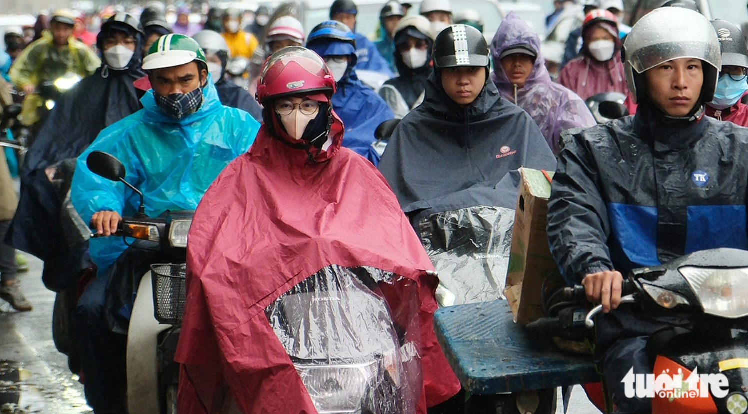 Hanoi residents pictured wearing a raincoat to commute in the chilly wind on November 13, 2023. Photo: Quang Vien / Tuoi Tre