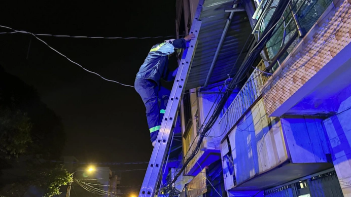 A rescuer climbs to the roof of a house to determine the position of the man.