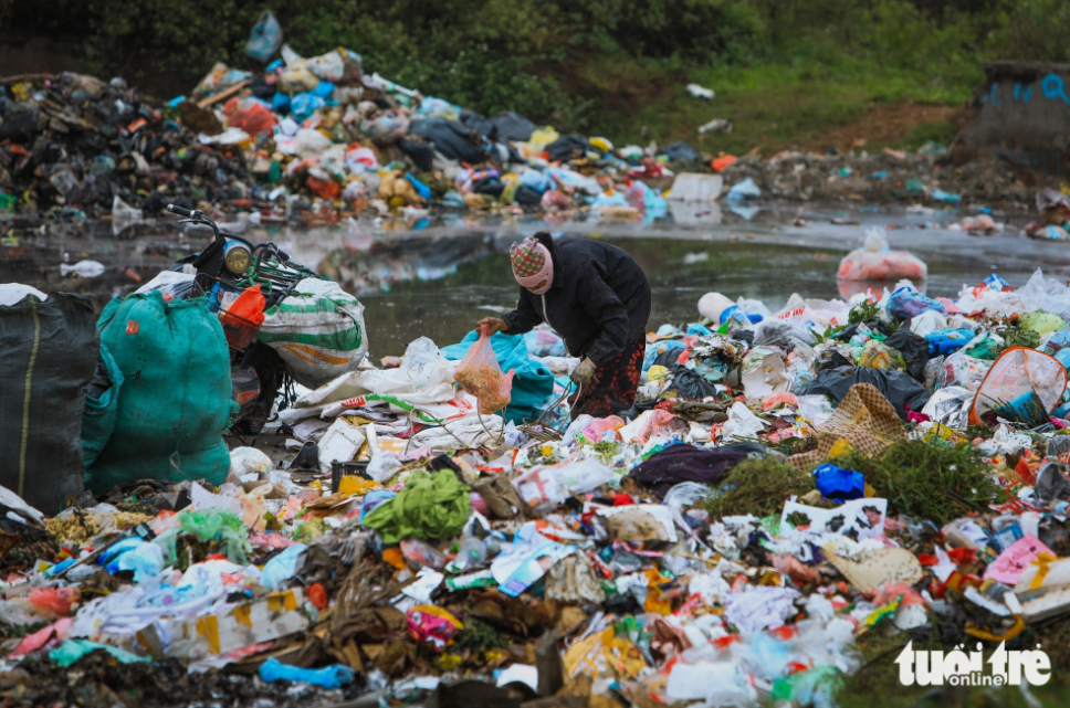 A woman collects scrap at a trash pickup site. Photo: Danh Khang / Tuoi Tre