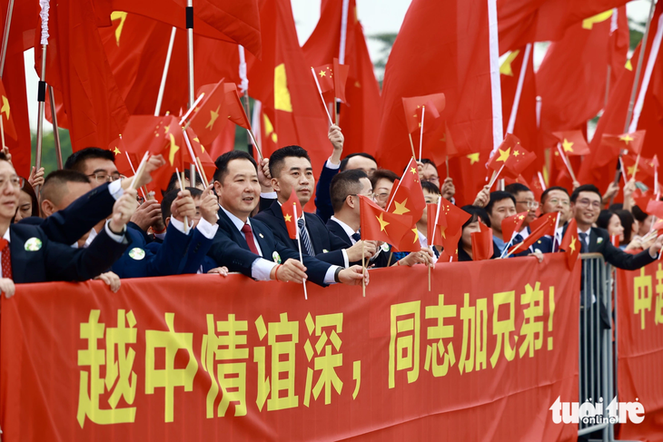 Chinese residents living and working in Vietnam welcome Chinese Party General Secretary and President Xi Jinping at the airport. Photo: Nguyen Khanh / Tuoi Tre