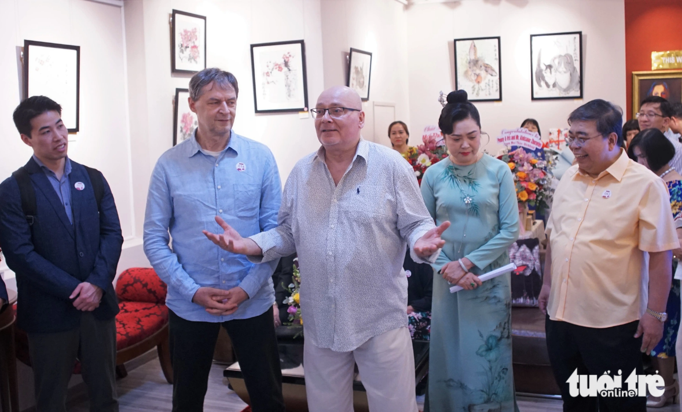 Russian artist Aleksandr Zhuravlev (C) is pictured expressing his happiness and sending gratitude to his Vietnamese friends for their support during his first exhibition in Vietnam. Photo: Huynh Vy / Tuoi Tre