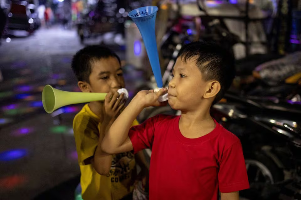 Children blow horns during New Year celebrations in Mandaluyong, Metro Manila, Philippines, December 31, 2023. Photo: Reuters