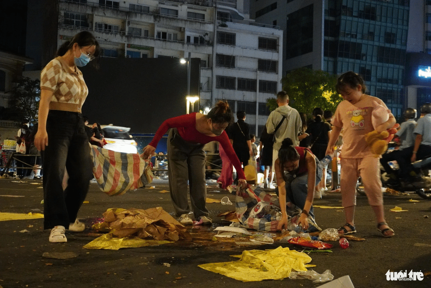 These young people clean up a trash-filled inner city area through the night. Photo: Xuan Huong / Tuoi Tre