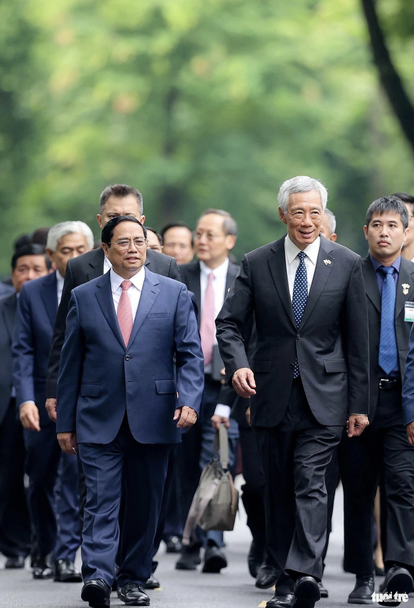 The two prime ministers of Vietnam and Singapore as well as other officials walk to the headquarters of the Government Office for talks. Photo: Nguyen Khanh / Tuoi Tre