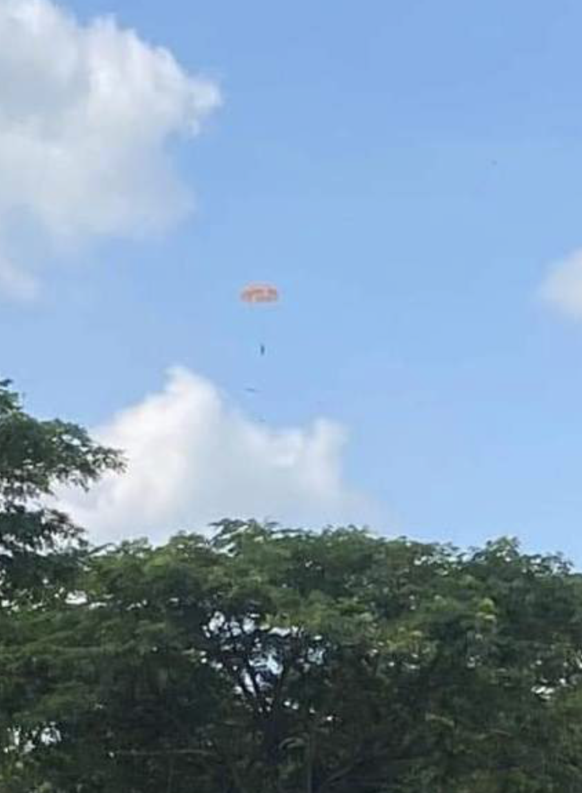  A still image taken from a video clip shows the pilot of a falling military plane jumping off it with a parachute