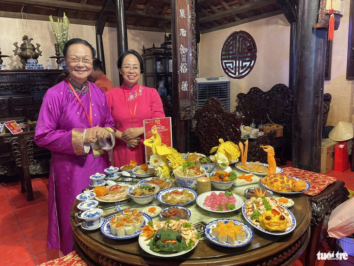 Artisans pose for a photo with an ancestral tray. Photo: N.Binh / Tuoi Tre