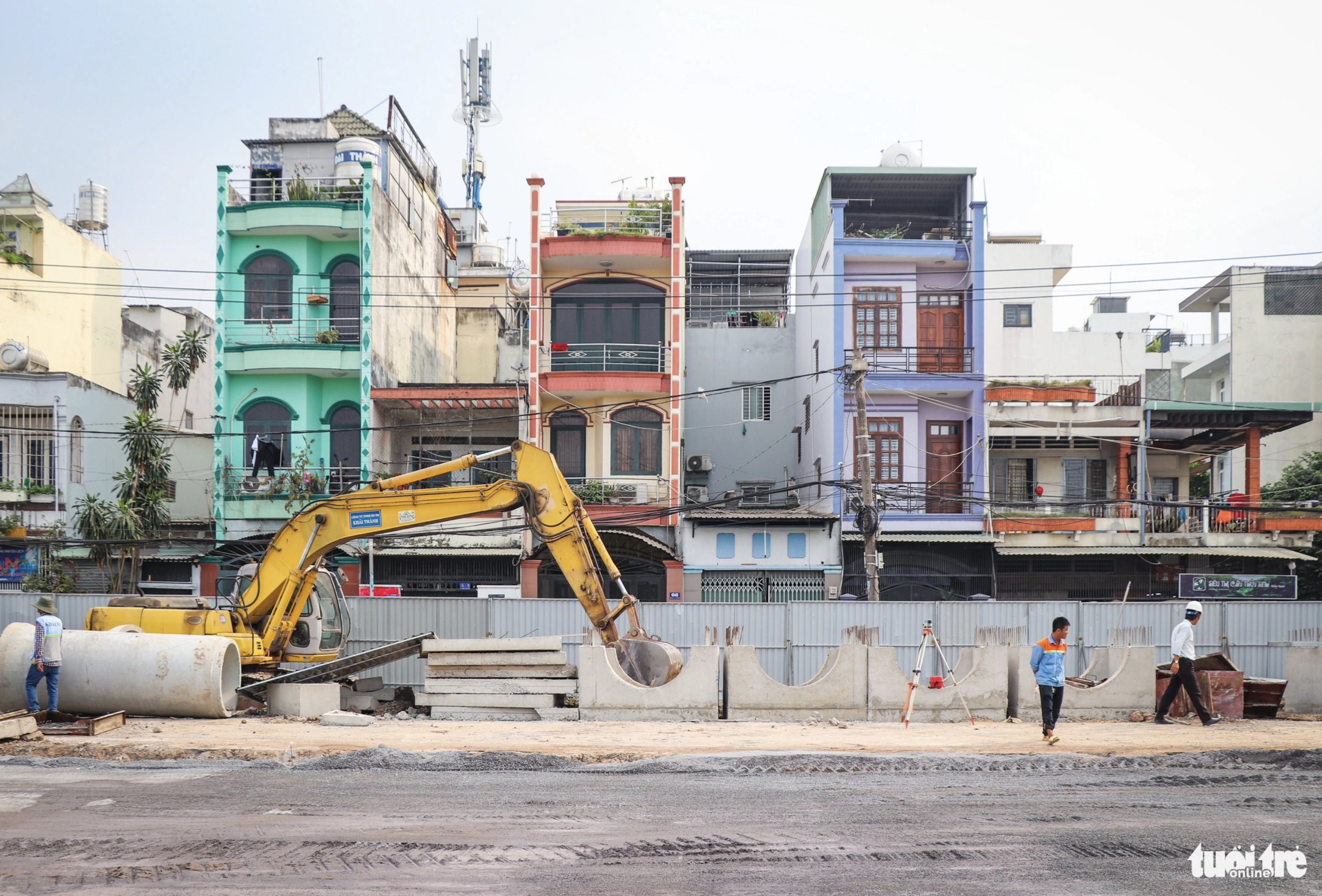  Construction workers inside the iron fence are busy building a road aimed at easing traffic jams facing the Tan Son Nhat International Airport area. Photo: Chau Tuan / Tuoi Tre