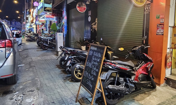 A restaurant on Phan Xich Long Food Street introduces its menu on the sidewalk to attract customers. Photo: Nguyen Tri / Tuoi Tre