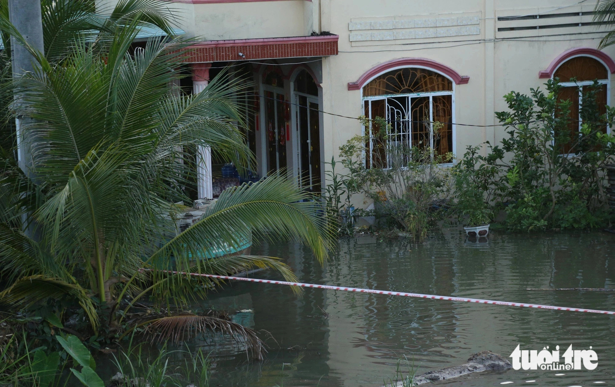 The yard of a local house is waterlogged as the result of high tide in Tien Giang Province, southern Vietnam. Photo: Hoai Thuong / Tuoi Tre