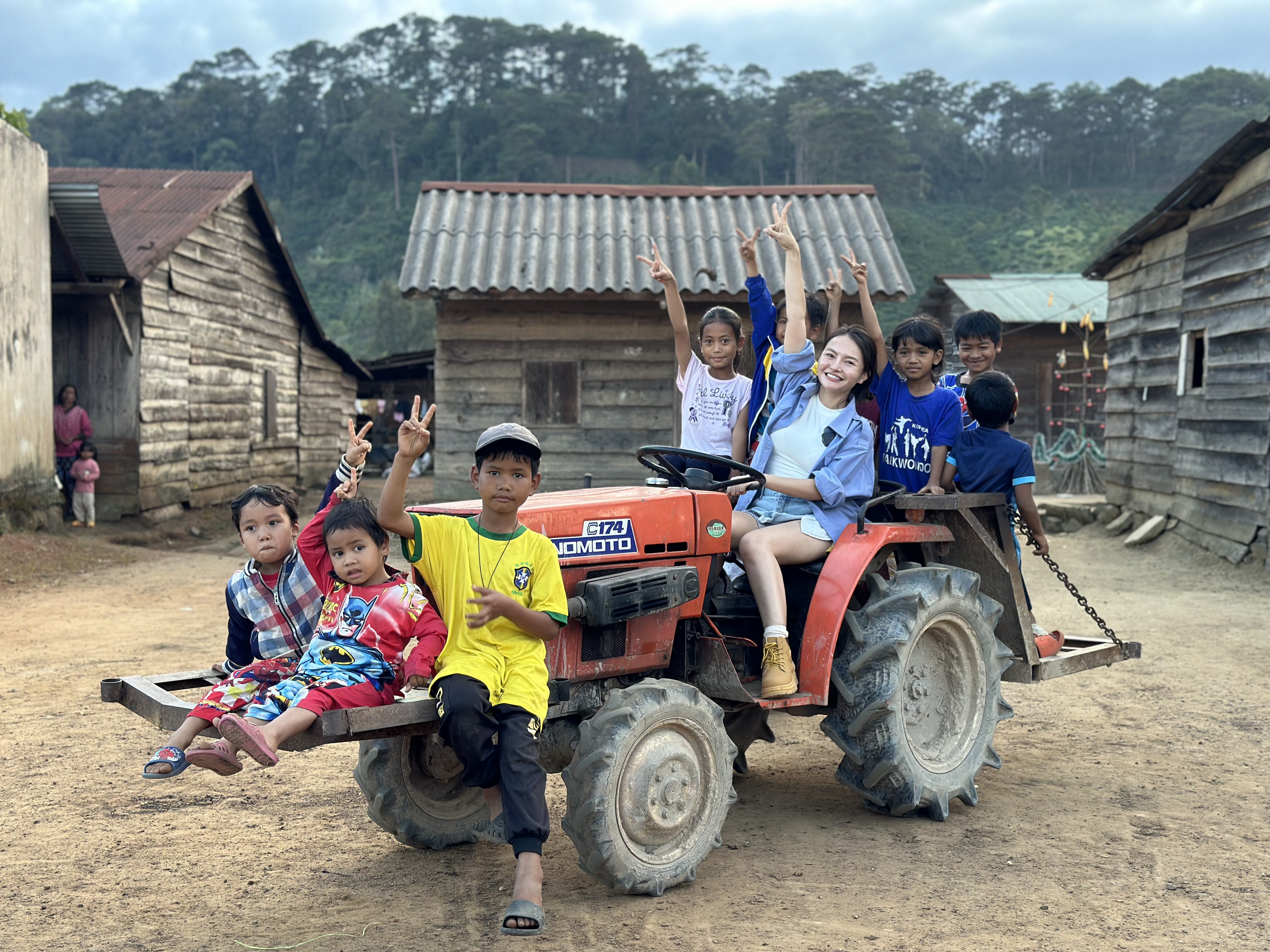 Dao Thuy Linh and local children pose for a photo during a 'Nau An Cho Em' event with Ma people in Loc Lam Commune, Bao Lam District, Lam Dong Province T December 2023. Photo: Supplied