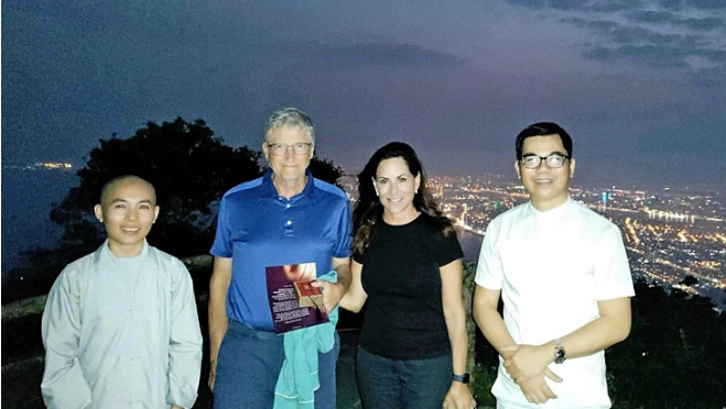 American billionaire Bill Gates (L, 2nd) and his girlfriend (next to Bill Gates) pose for a photo with Vietnamese artisan Hoang Anh Suong (R) after drinking tea and enjoying the fresh air on Ban Co (Chess Board) Peak on Son Tra Mountain in Da Nang City. Photo: Facebook Hoang Anh Suong