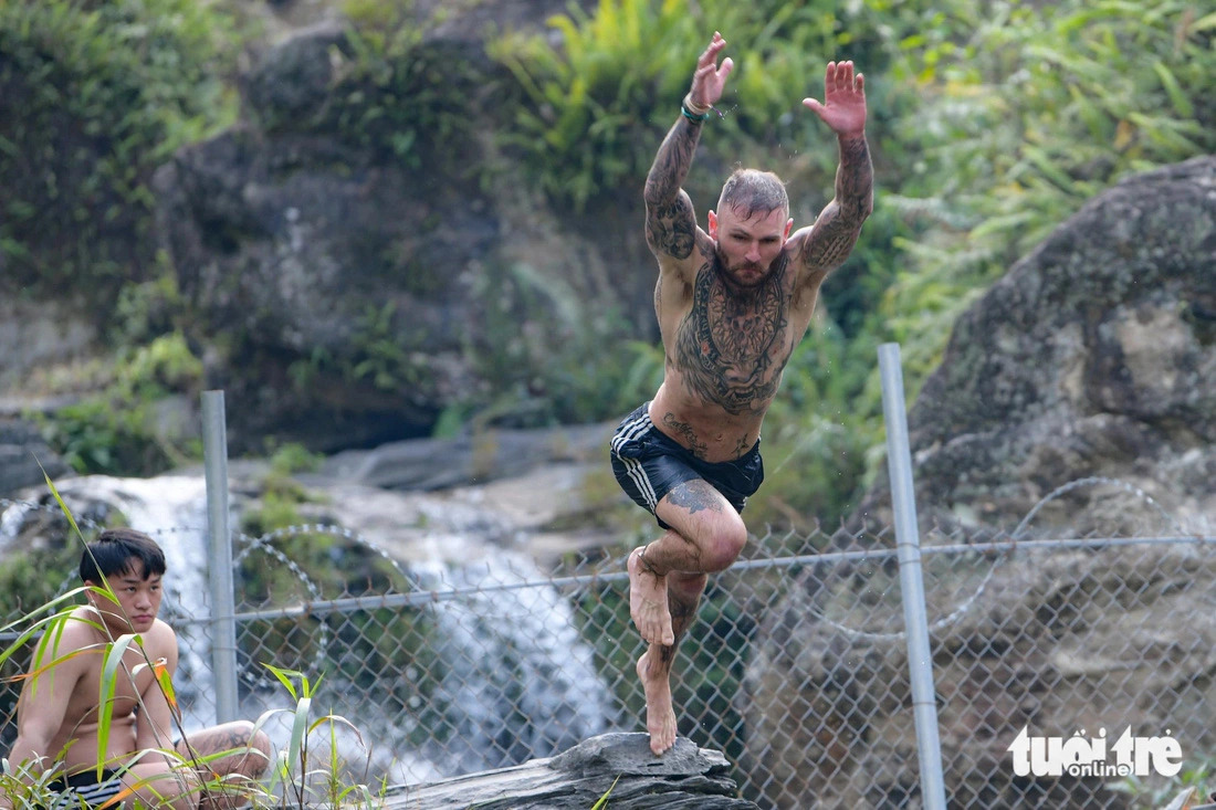A foreign man is seen starting a jump from a high rock at a height of six meters into the water pool at the Du Gia waterfall in Ha Giang Province, northern Vietnam. Photo: Nam Tran / Tuoi Tre