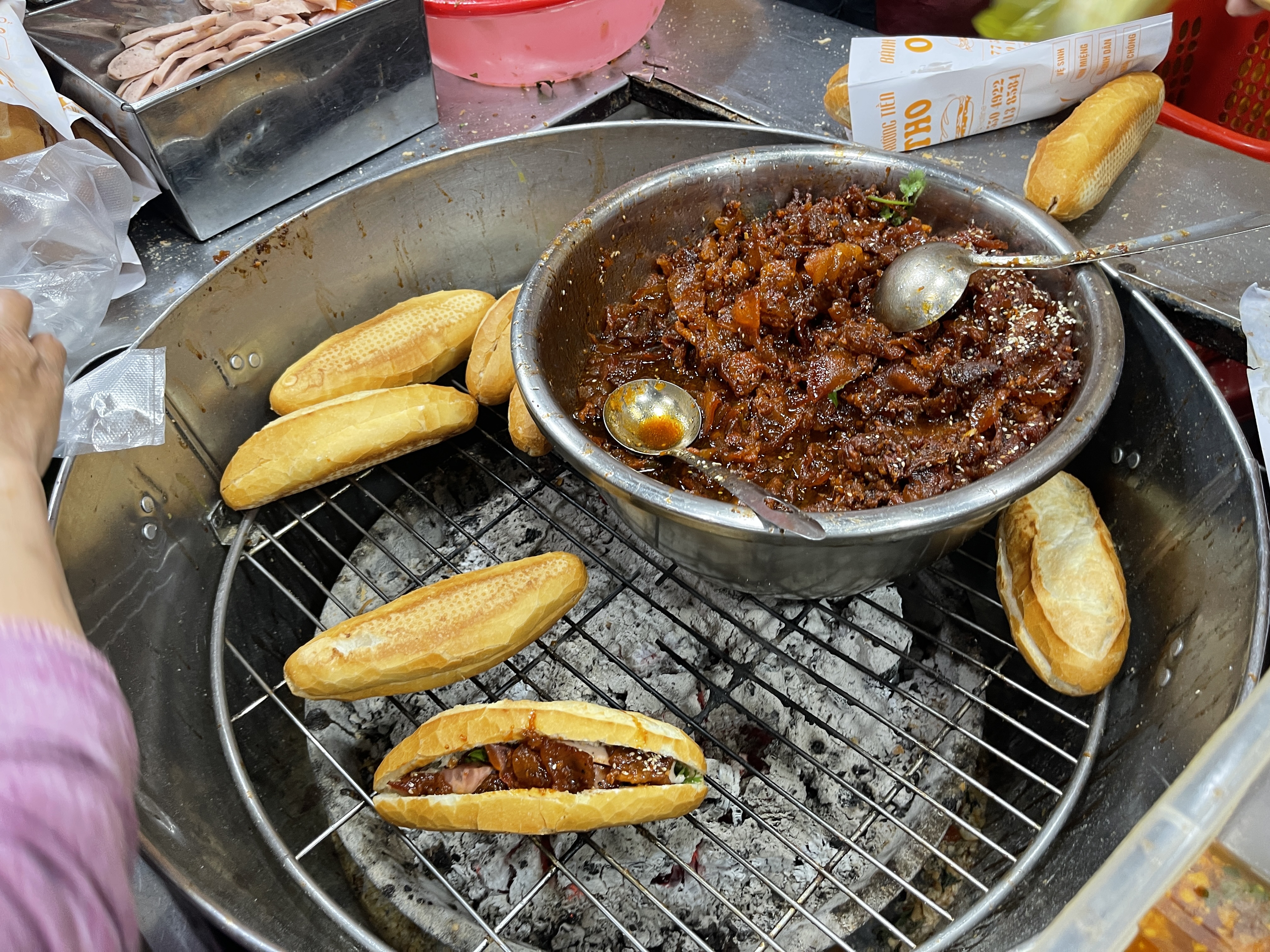 Loafs of ‘bánh mì’ are heated on a charcoal stove at Bánh Mì Trường Tiền O Tho shop in Hue City, Vietnam. Photo: Dong Nguyen / Tuoi Tre News