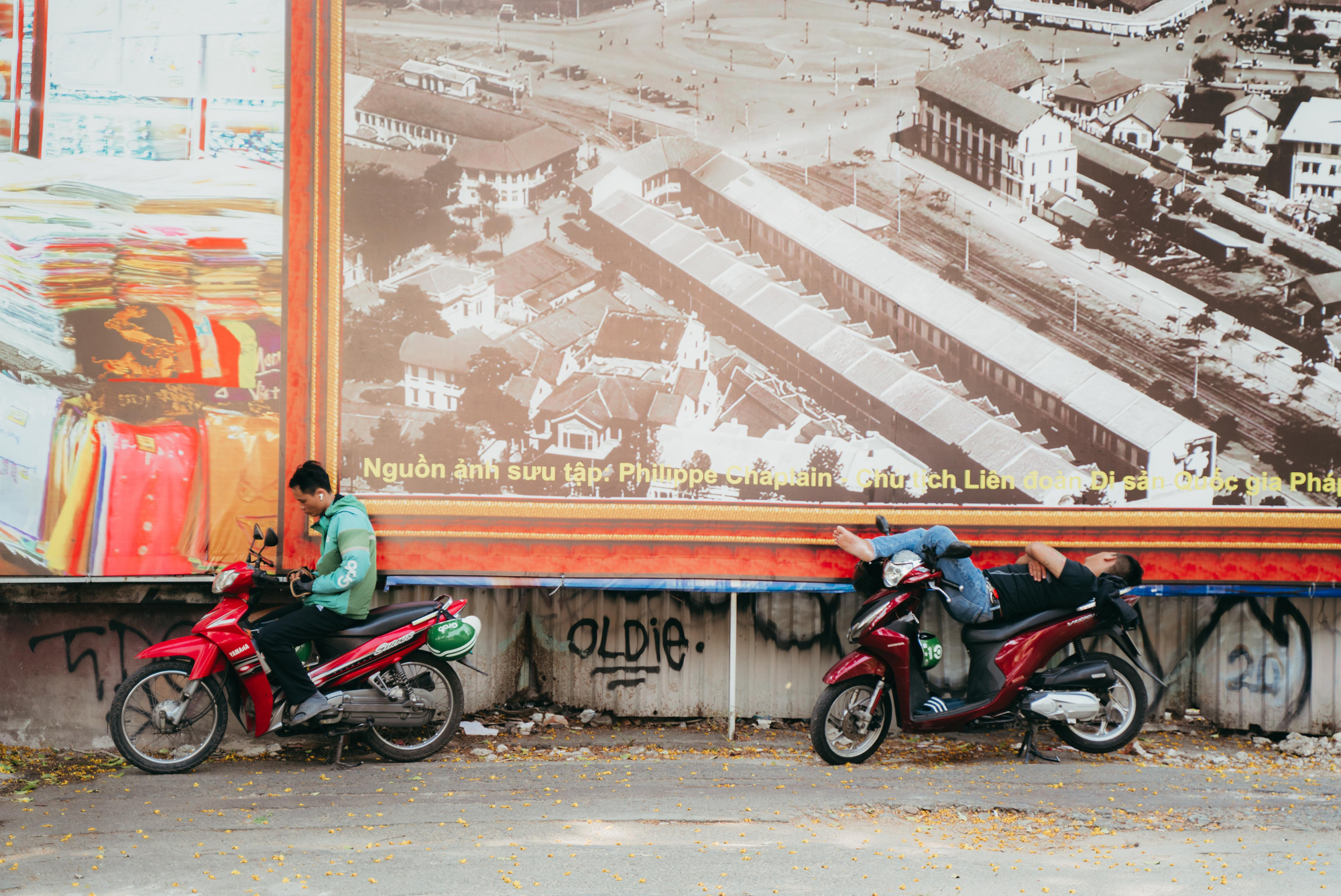 A ride-hailing driver takes a respite under a signage in Ho Chi Minh City. Photo: Thanh Hiep / Tuoi Tre