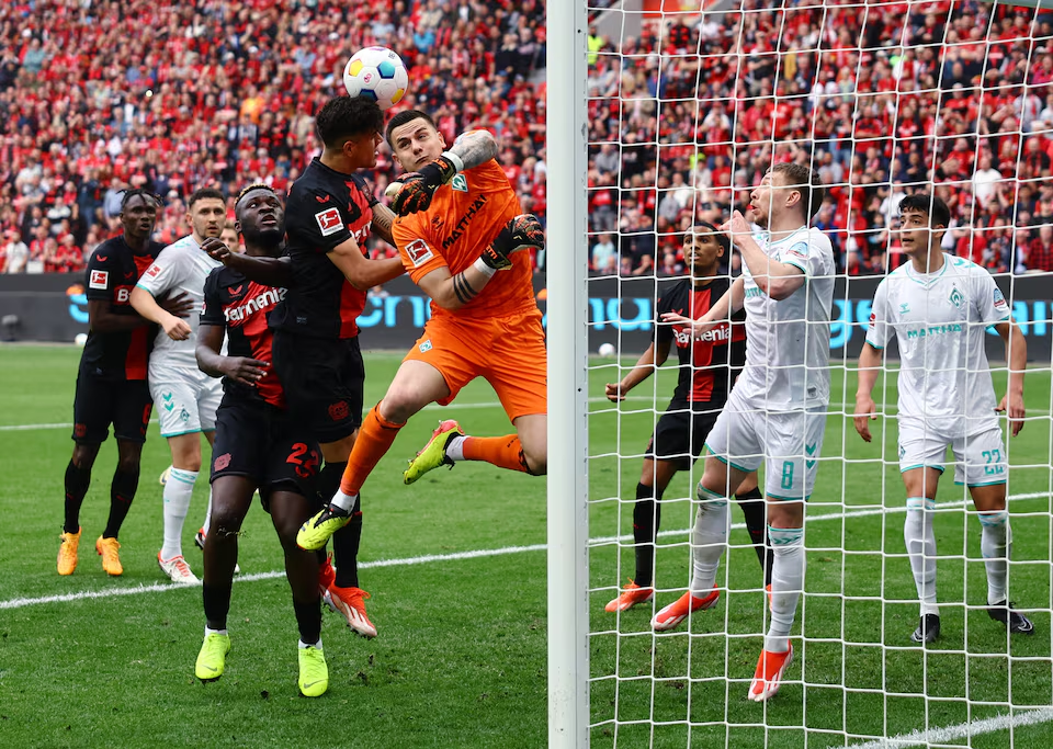 Soccer Football - Bundesliga - Bayer Leverkusen v Werder Bremen - BayArena, Leverkusen, Germany - April 14, 2024 Werder Bremen's Michael Zetterer in action with Bayer Leverkusen's Victor Boniface and Piero Hincapie. Photo: Reuters