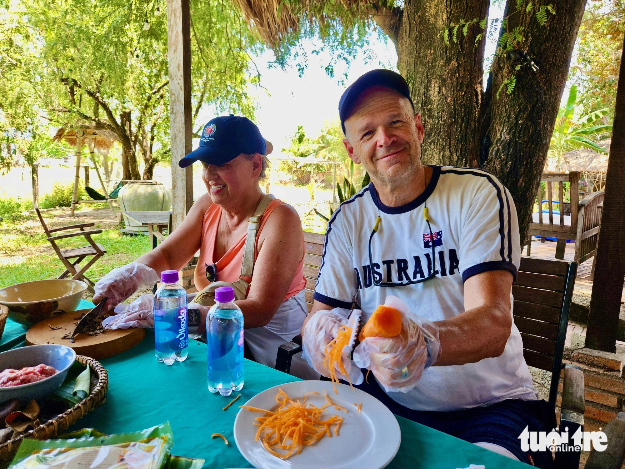 Pruce Godke (R), an American traveler, is seen excitedly practicing making spring rolls, one of the traditional Vietnam dishes, during his countryside tour in Nha Trang City, Khanh Hoa Province, south-central Vietnam. Photo: Minh Chien / Tuoi Tre