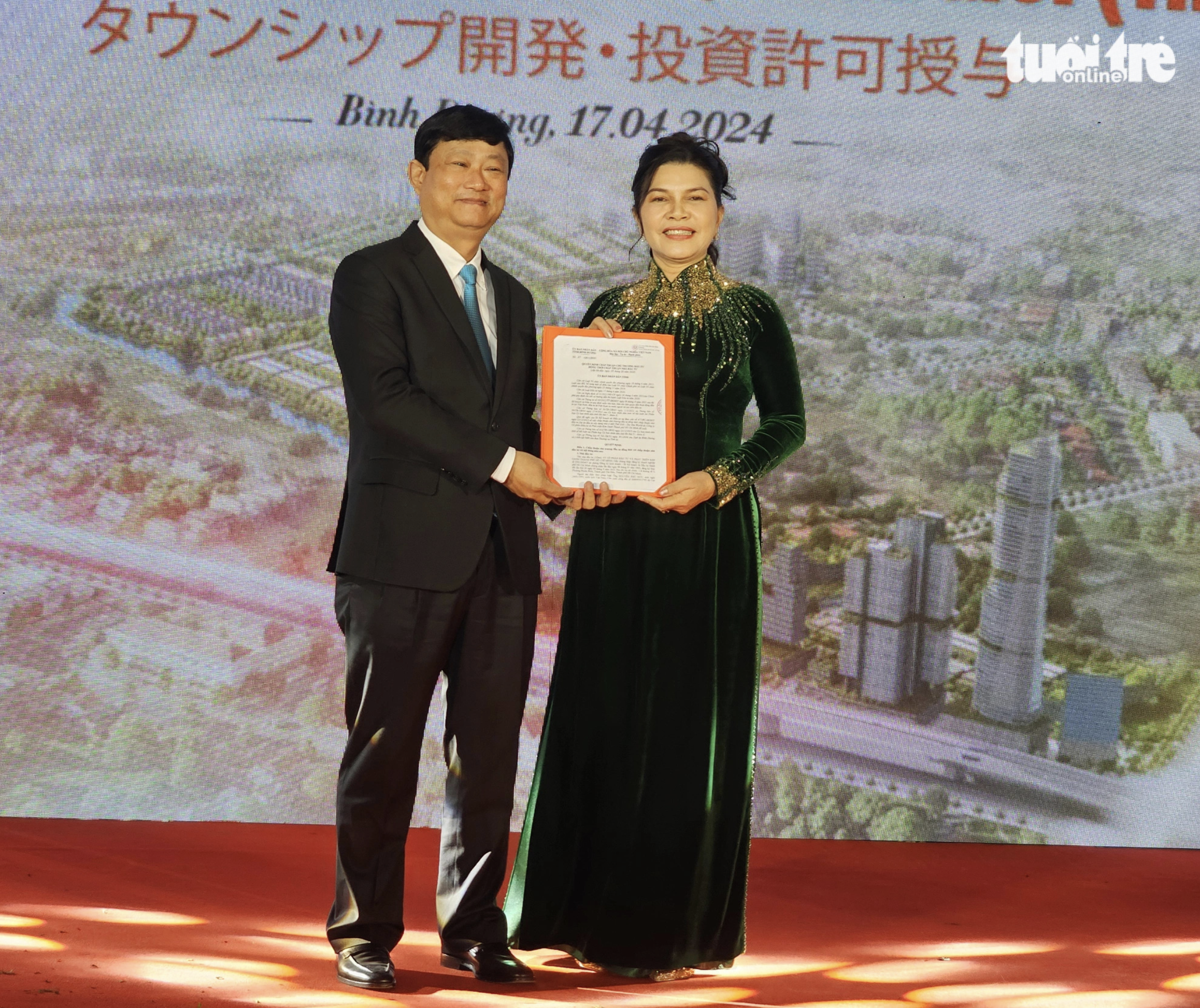 The chairman (L) of the Binh Duong Province People’s Committee awards an investment certificate to the investor of the ‘The One World’ urban area project in the province. Photo: Ba Son / Tuoi Tre