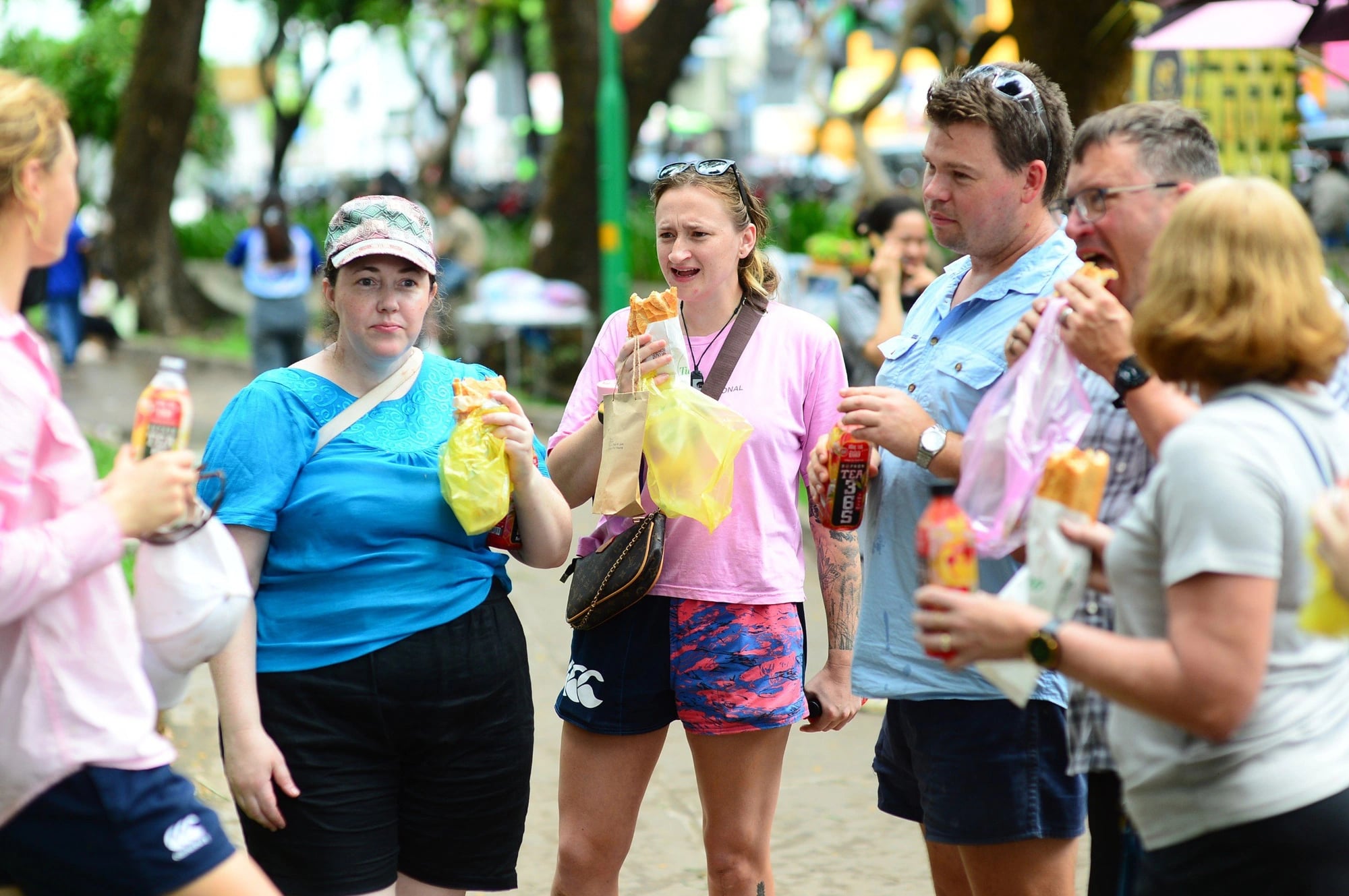 A group of tourists from New Zealand enjoy ‘banh mi’ at the Vietnam Banh Mi Festival at Le Van Tam Park in District 1, Ho Chi Minh City on May 17. Photo: Quang Dinh / Tuoi Tre