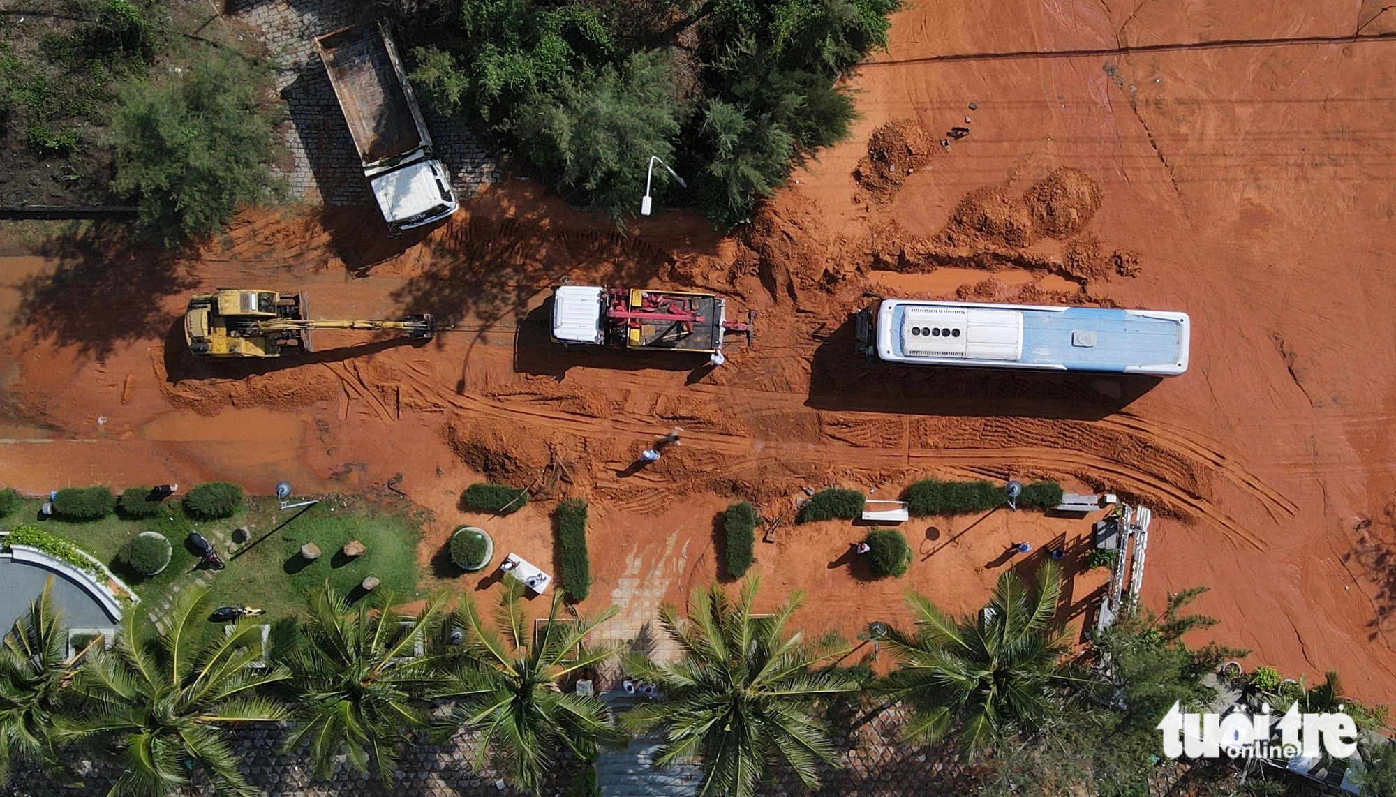 A sleeper bus is stuck in a thick layer of red sand in Phan Thiet City, Binh Thuan Province, south-central Vietnam. Photo: Duc Trong / Tuoi Tre