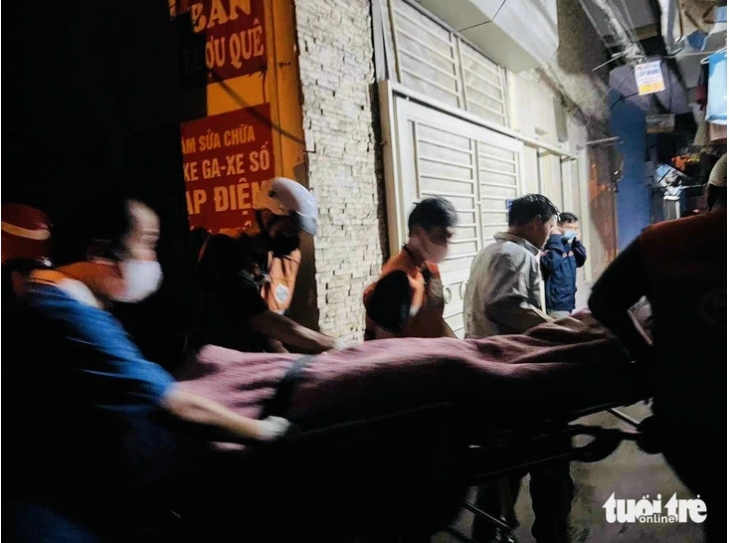 The body of a dead person is moved out of the house. Photo: Minh Thanh / Tuoi Tre