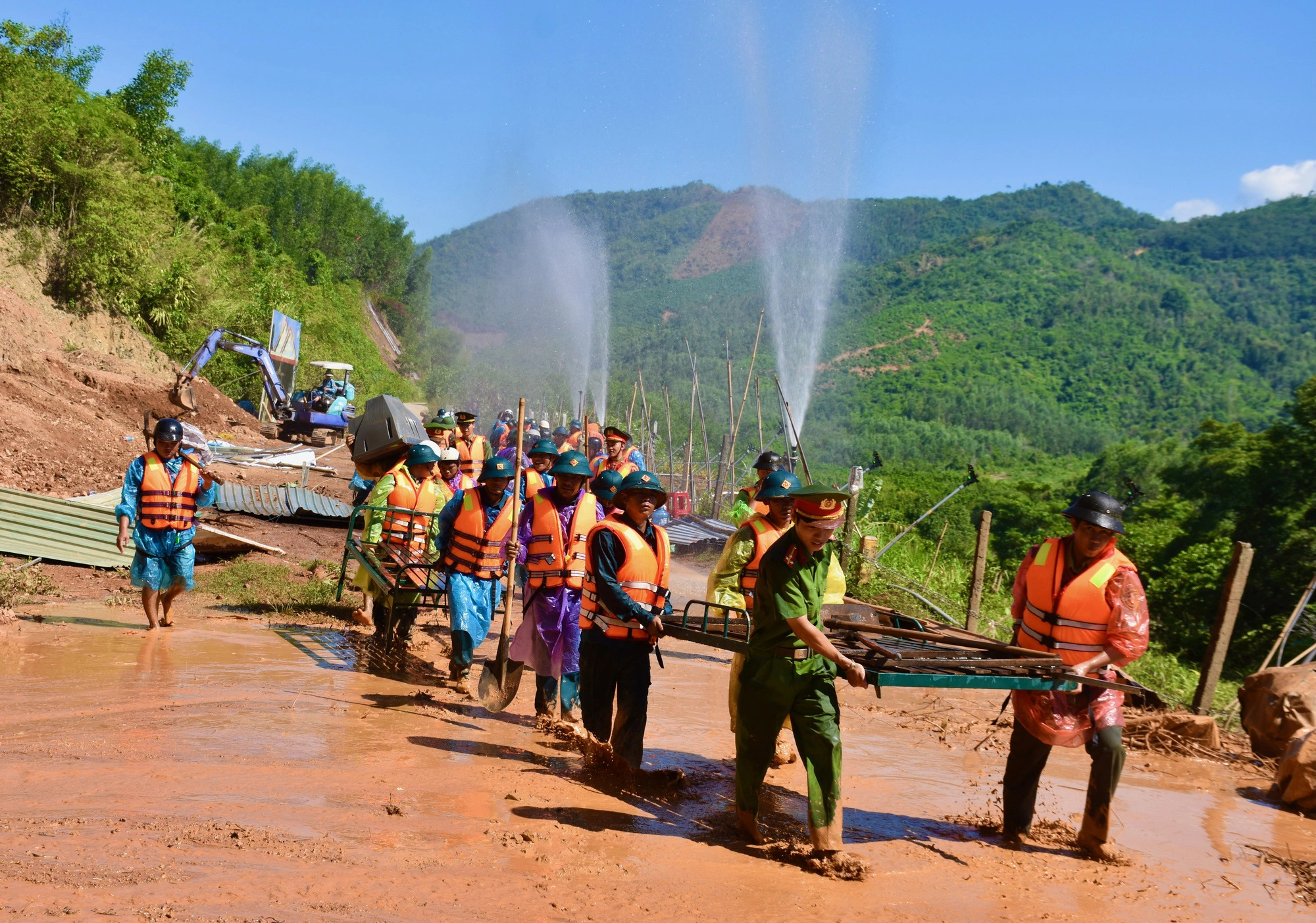Rescuers take household items of landslide-hit residents out of the scene of the incident. Photo: Minh Chien / Tuoi Tre