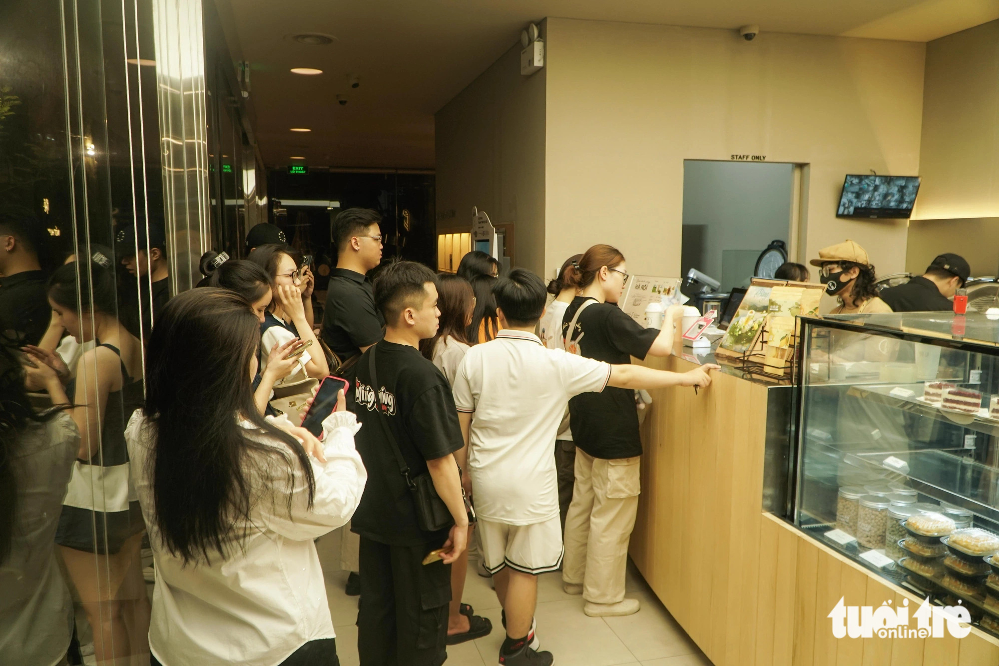 Customers line up at the order counter at a coffee shop on Tong Dan Street in Hoan Kiem District, Hanoi, at dawn on June 14, 2024. Photo: Pham Tuan / Tuoi Tre