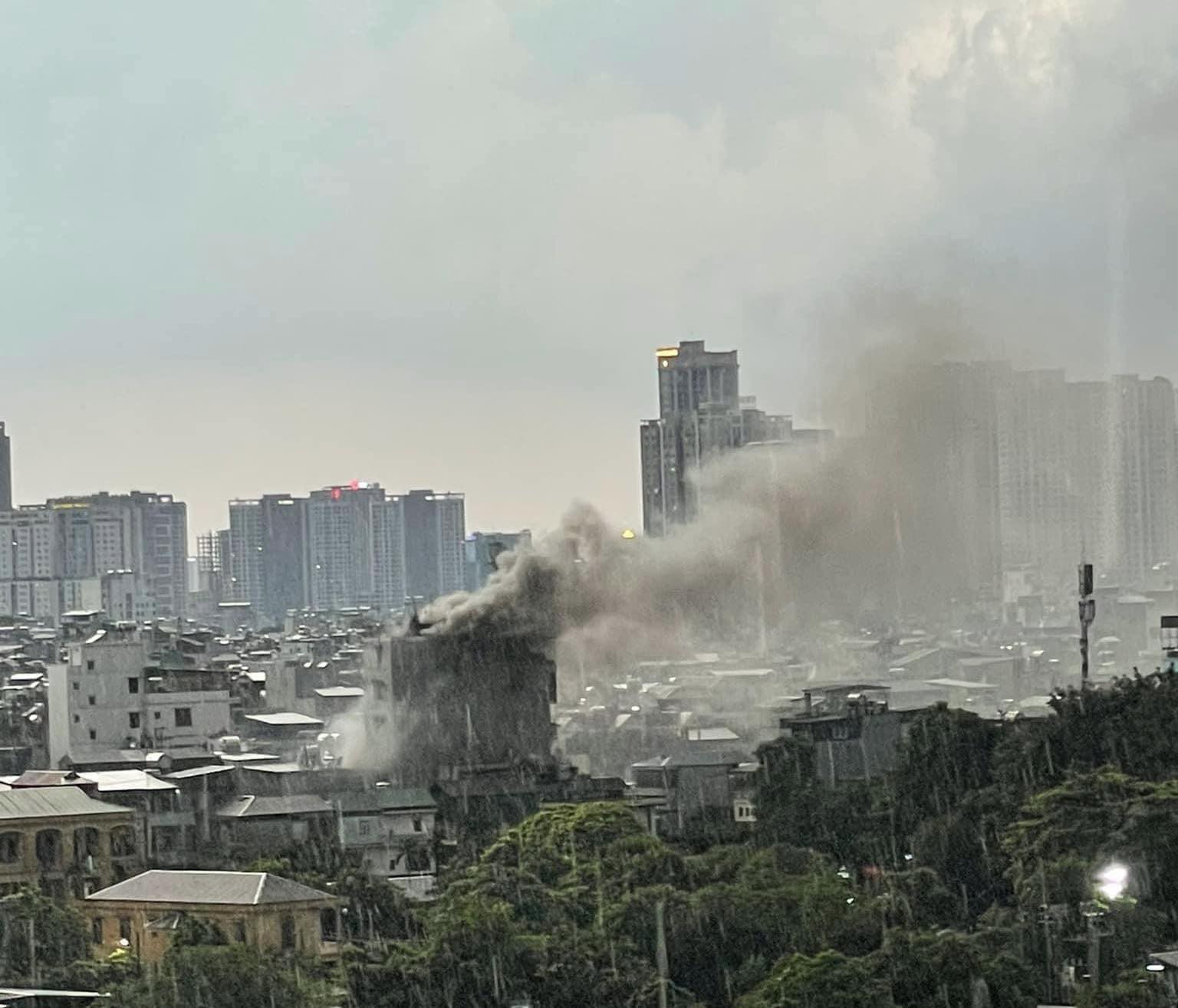 A cloud of smoke rises from a burning five-story house during a downpour in Hoang Mai District, Hanoi on June 16, 2024. Photo: Hoai Nguyen