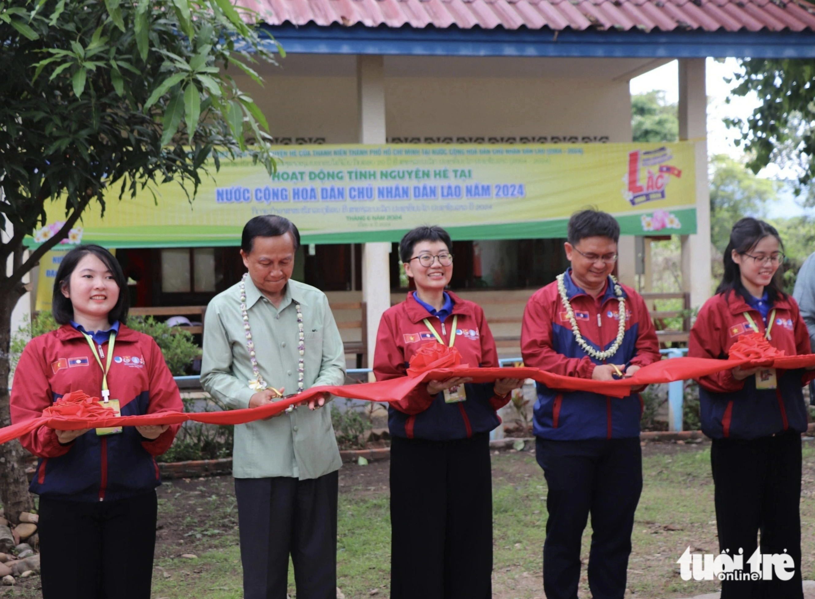 Representatives cut a ribbon to inaugurate a playground for students and embellished classrooms at Kilomet Elementary School No. 3 in Laos. Photo: Dieu Qui / Tuoi Tre