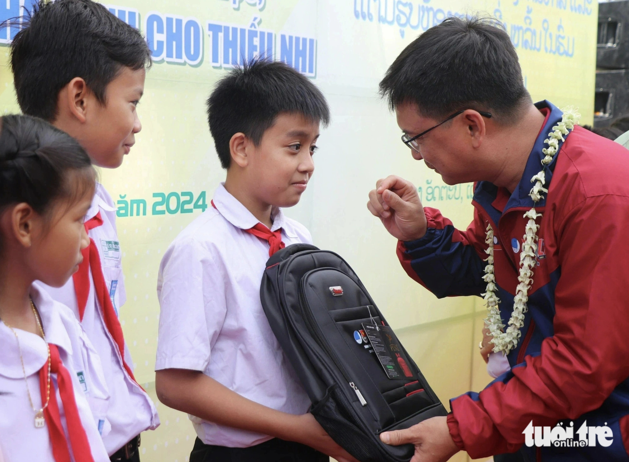 Nguyen Manh Cuong, head of the Ho Chi Minh City Party Committee's Commission for Mass Mobilization, presents backpacks to Laotian students. Photo: Dieu Qui / Tuoi Tre