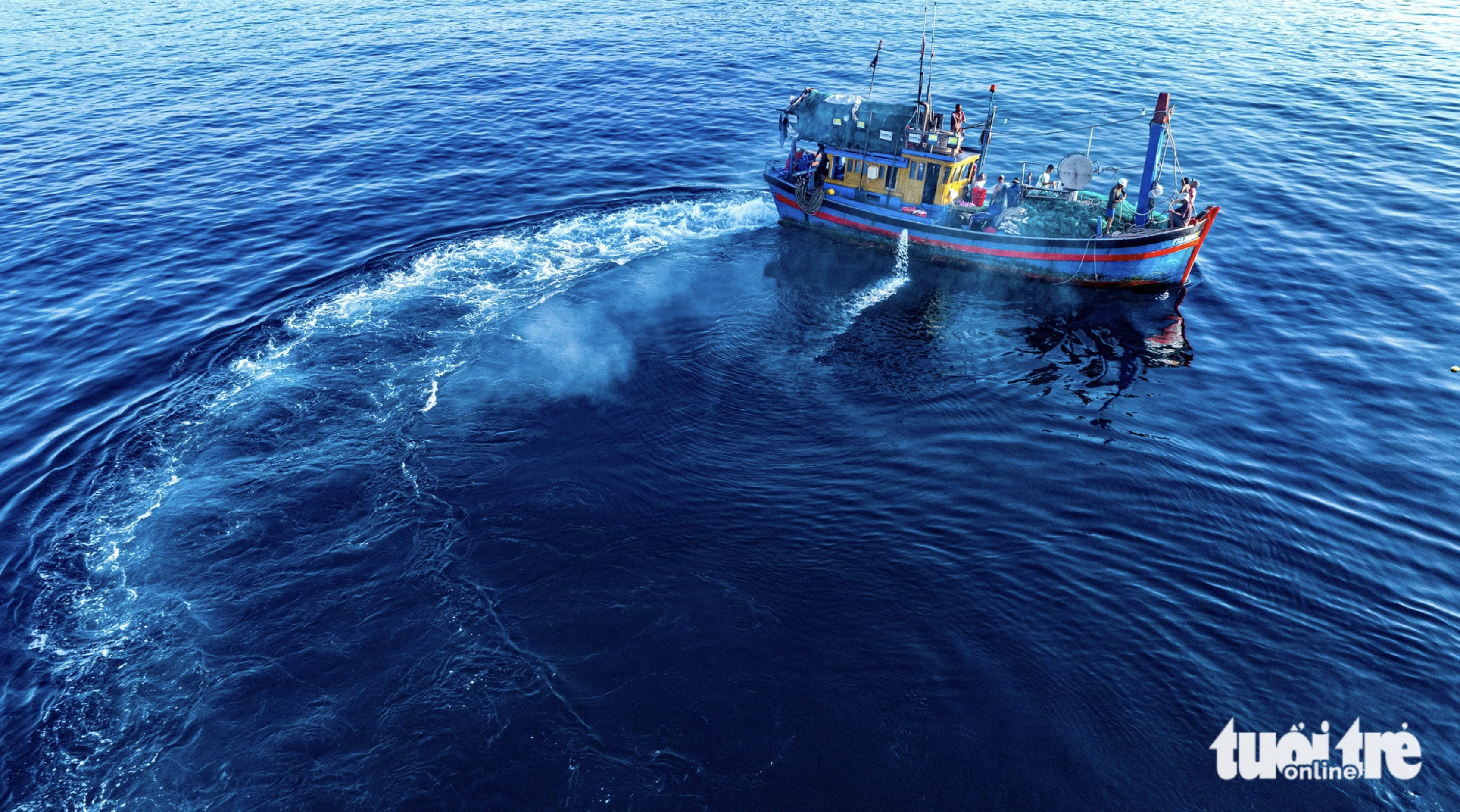 A boat gets ready to throw a fishing net to catch anchovies in the waters off Phu Yen Province, south-central Vietnam.