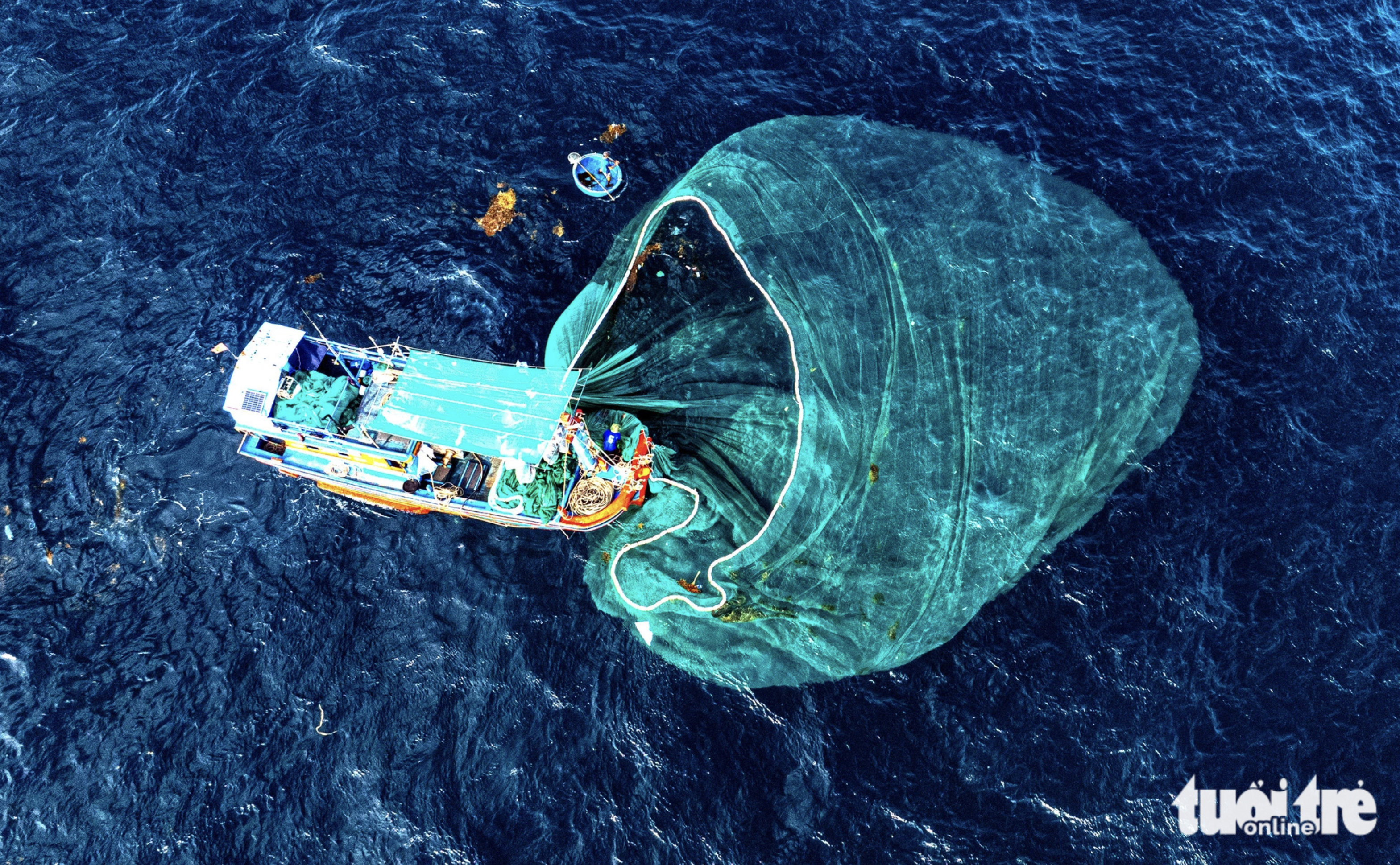A boat is harvesting anchovies with a net in the waters off Phu Yen Province, south-central Vietnam.