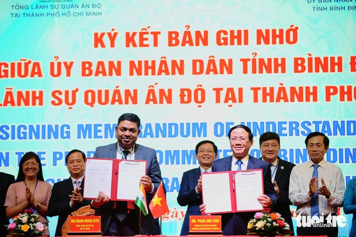 Indian Consul General in Ho Chi Minh City Madan Mohan Sethi (L) and chairman of the Binh Dinh administration Pham Anh Tuan show the memorandum of understanding on investment cooperation they signed at a conference in Binh Dinh Province on June 25, 2024. Photo: Lam Thien / Tuoi Tre
