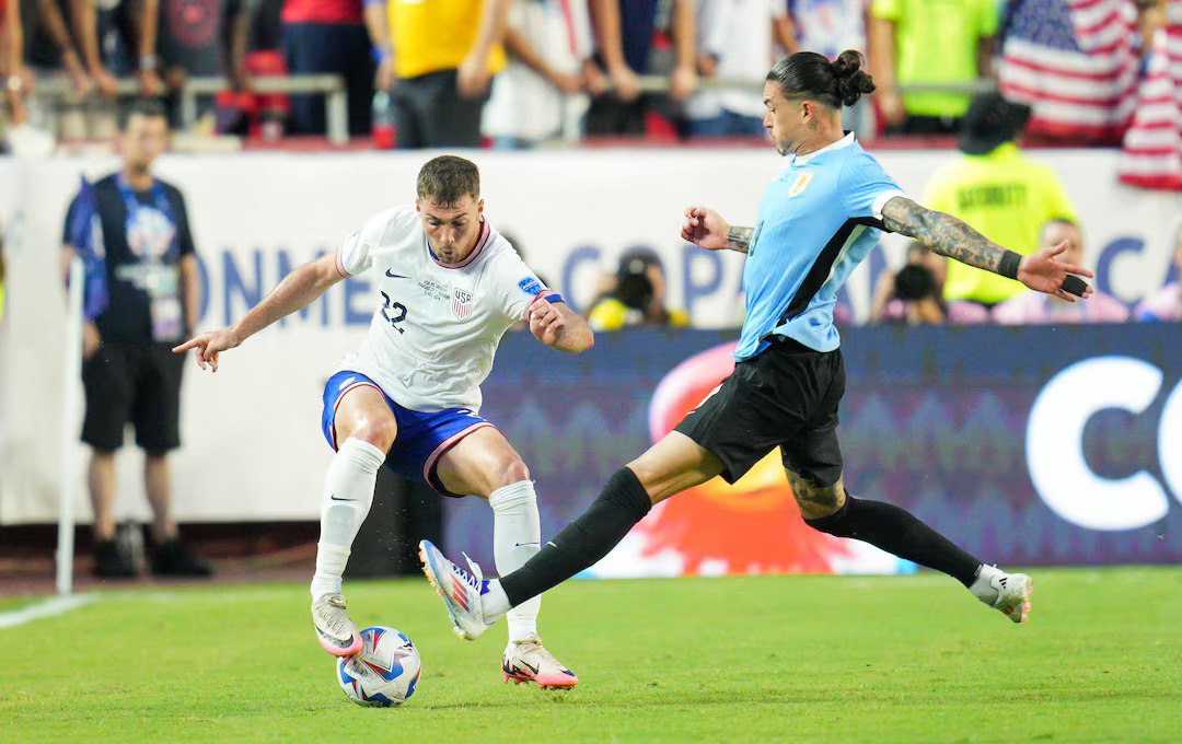 Jul 1, 2024; Kansas City, Missouri, USA; United States defender Joe Scally (22) is tackled by Uruguay forward Darwin Nunez (19) during the first half of a Copa America match at Arrowhead Stadium. Photo: USA TODAY Sports