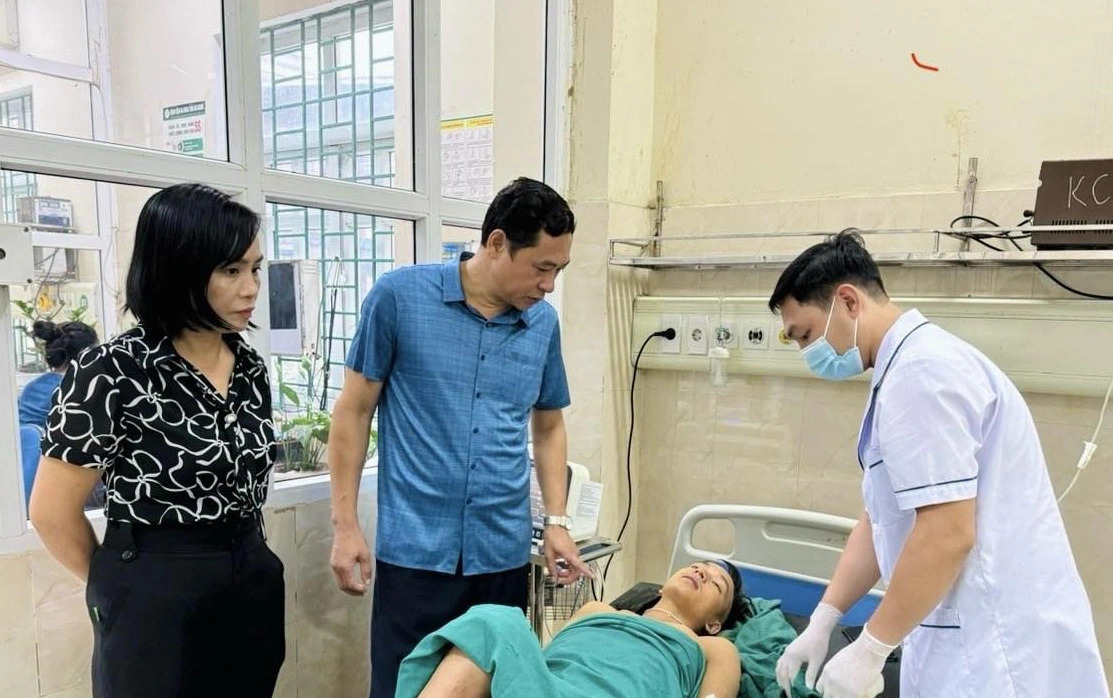 Nguyen Van Giao (in blue T-shirt), director of the Health Department in Ha Giang Province, northern Vietnam, visits a victim who suffered injuries in the fatal landslide. Photo: Supplied