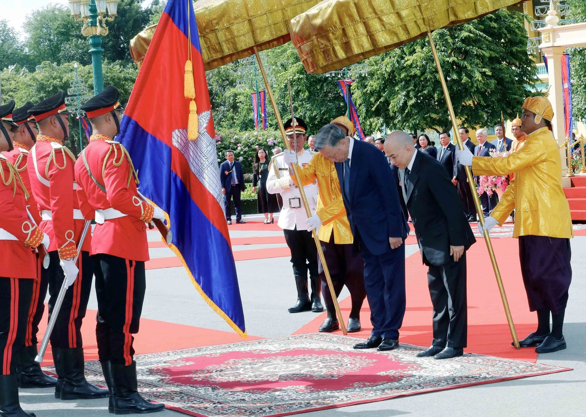 The two top Vietnamese and Cambodian officials walk a red carpet together while reviewing the honor guard at the Royal Palace in Phnom Penh, July 12, 2024. Photo: Vietnam News Agency