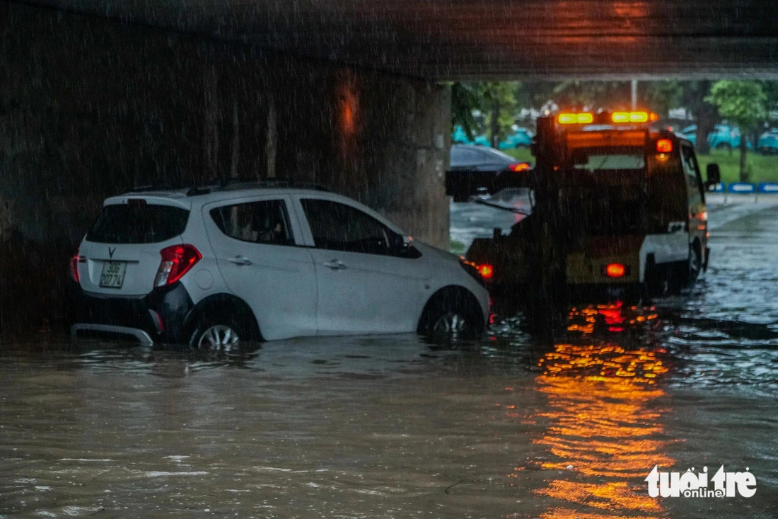 A rescue vehicle tows a broken-down car out of a tunnel area of Thang Long Avenue in Hanoi during a prolonged downpour on July 23, 2024. Photo: Pham Tuan / Tuoi Tre