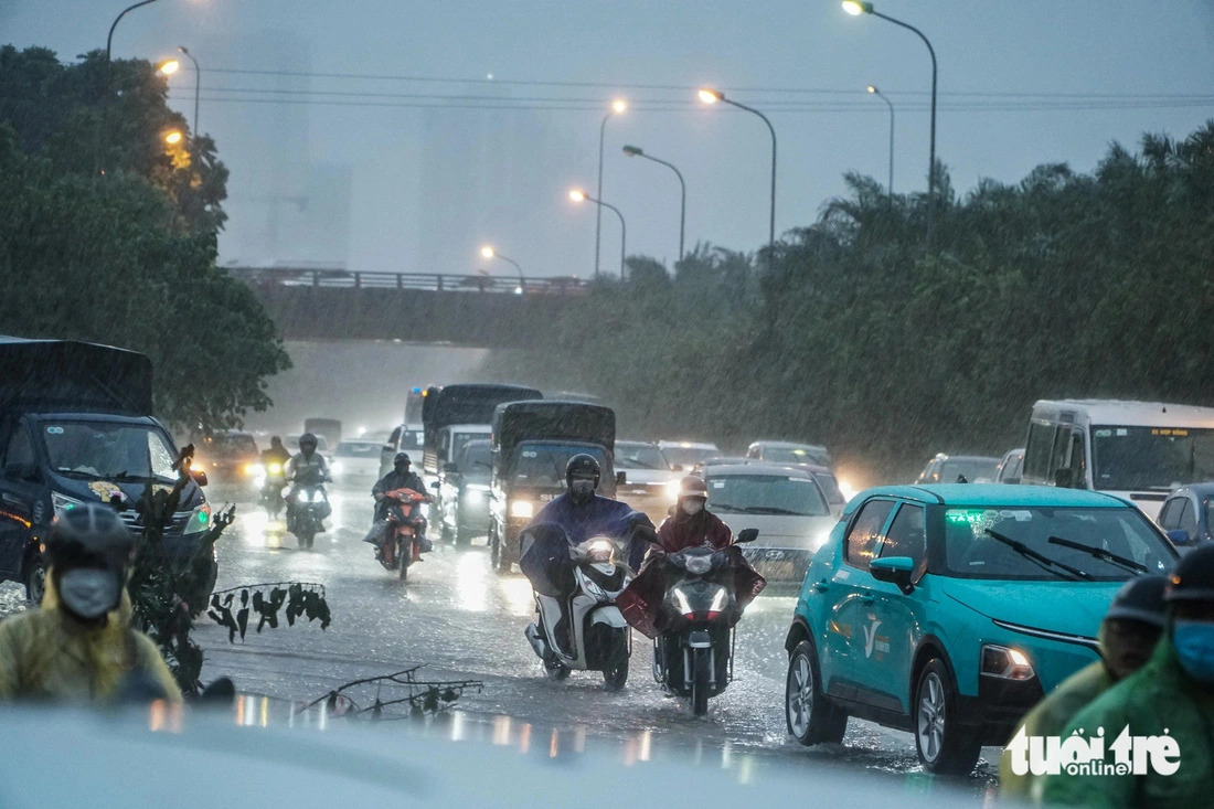 Vehicles move very slowly on the crowded Thang Long Avenue collector road in Hanoi under the heavy rain on July 23, 2024. Photo: Pham Tuan / Tuoi Tre