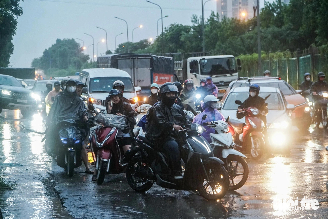 Vehicles have to stop in front of a seriously inundated area on a street in Hanoi, leading to congestion during the torrential rain on July 23, 2024. Photo: Pham Tuan / Tuoi Tre