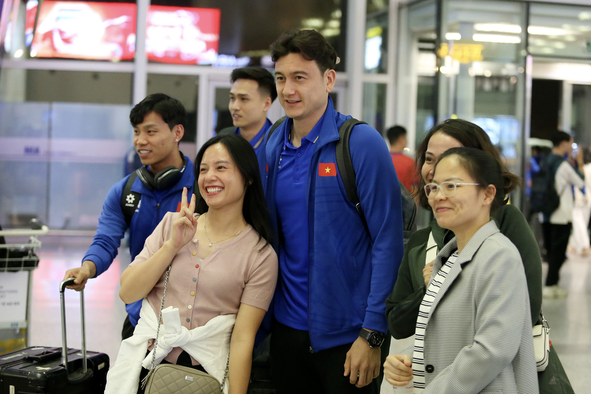 A member of the Vietnamese national men’s football team poses for a photo with fans before his departure for South Korea from Noi Bai International Airport in Hanoi, November 23, 2024. Photo: Huu Tan / Tuoi Tre