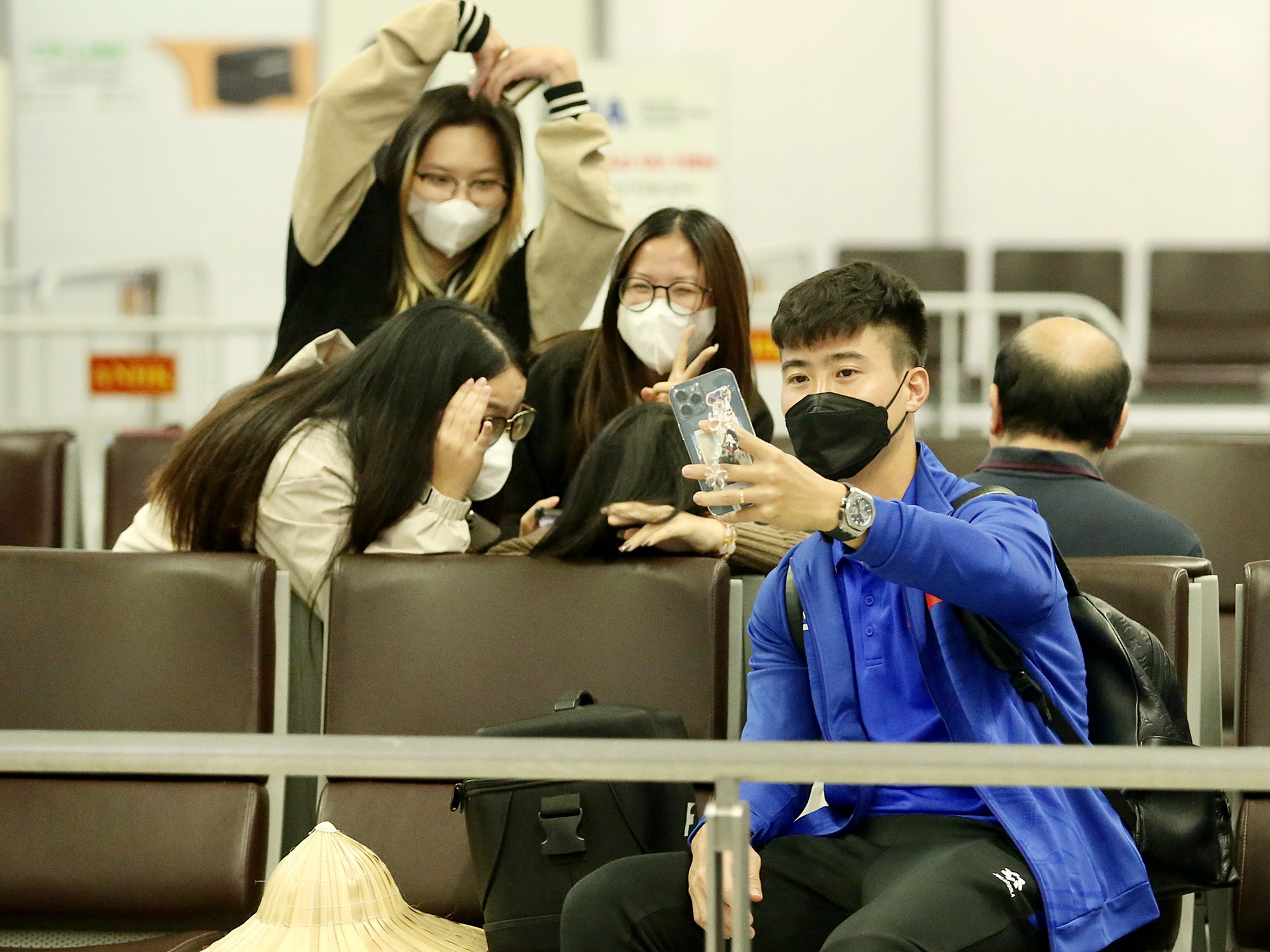 A member of the Vietnamese national men’s football team take a we-fie with fans before his departure for South Korea from Noi Bai International Airport in Hanoi, November 23, 2024. Photo: Huu Tan / Tuoi Tre