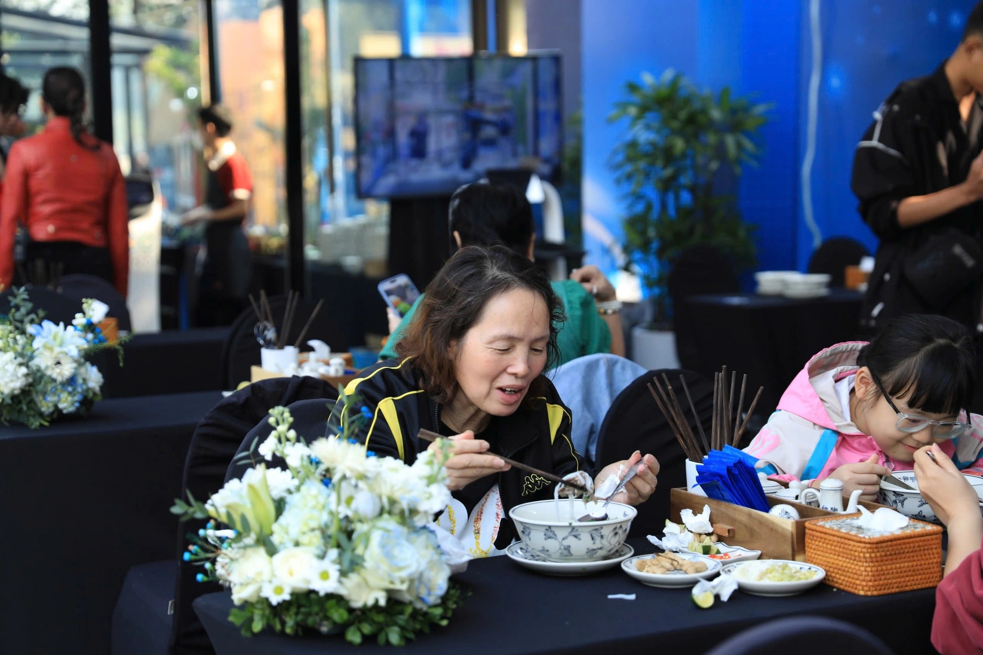 Visitors enjoy the novelty of eating robot-served Phở - Photo: Tuan Anh / Tuoi Tre