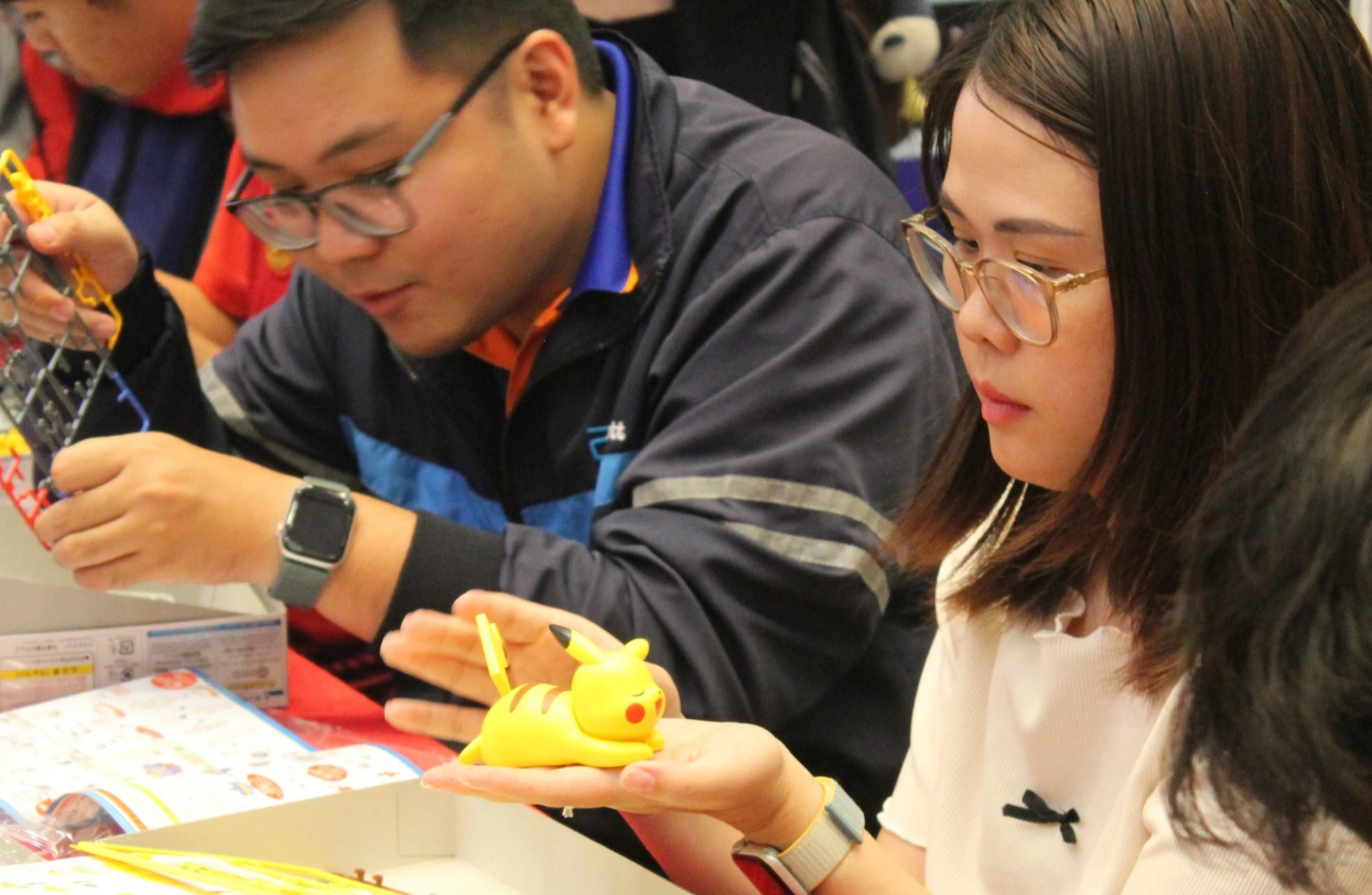 Both male and female visitors join a model-building activity at the Bandai Spirits Hobby Exhibition at Aeon Mall in Binh Tan District, Ho Chi Minh City. Photo: To Cuong / Tuoi Tre
